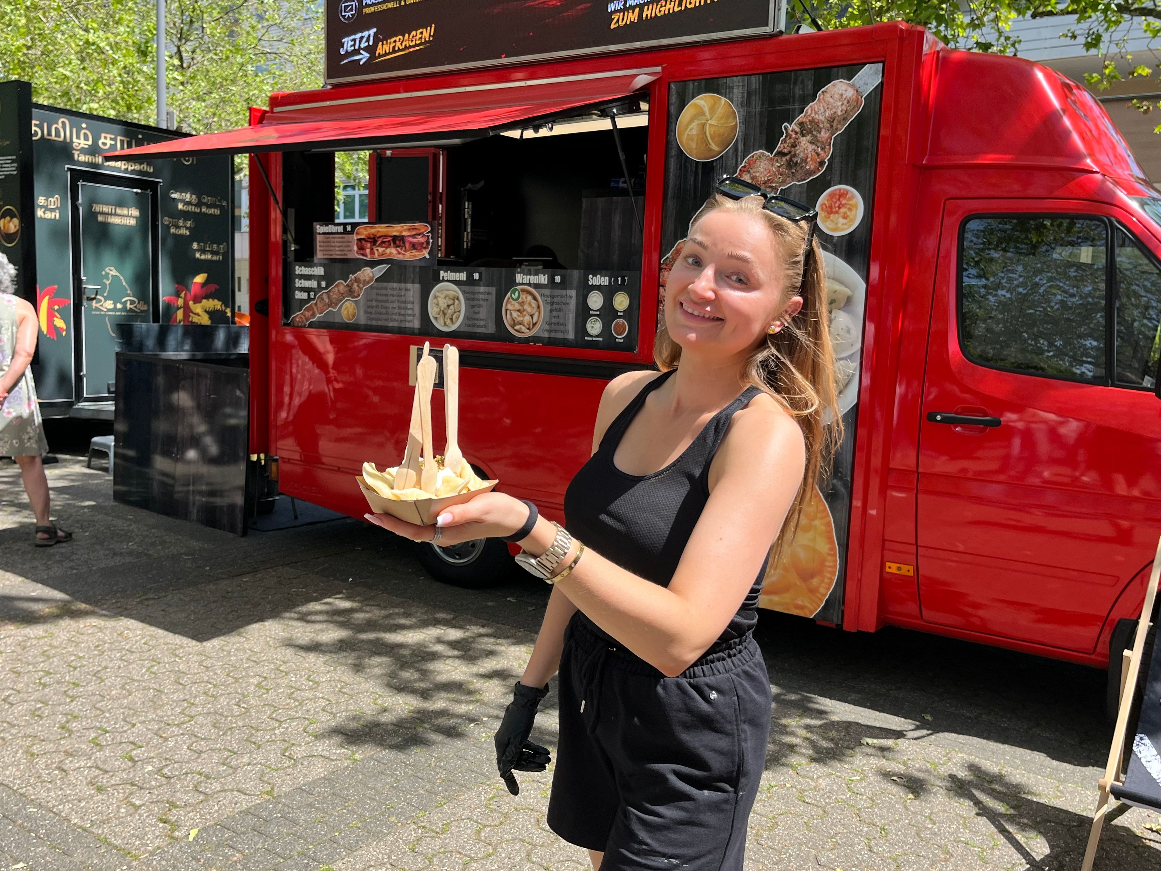 Zu sehen ist eine Frau, die ein Schälchen mit Teigtaschen in der Hand hält.