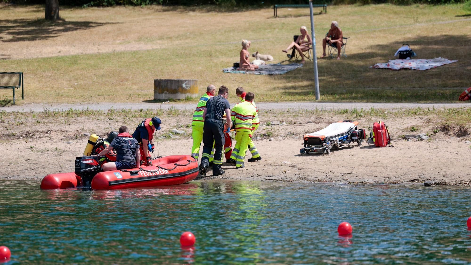 Einsatzkräfte der Berufsfeuerwehr Köln, der DLRG (Deutsche Lebens-Rettungs-Gesellschaft) und von den Rettungstauchern (Wasserrettung) simulieren die Rettung einer Person aus dem Fühlinger See, um dabei auch über die Risiken in Gewässern und beim Schwimmen aufzuklären. (Archivbild)