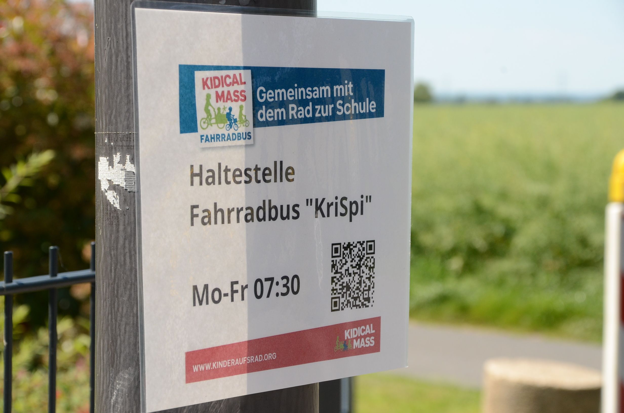Ein laminiertes Papier mit der Aufschrift Haltestelle Fahrradbus KriSpi.