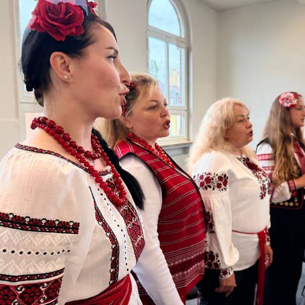 Die Sängerinnen stehen nebeneinander. Sie tragen die bestickten folkloristischen Kleider der Ukraine.