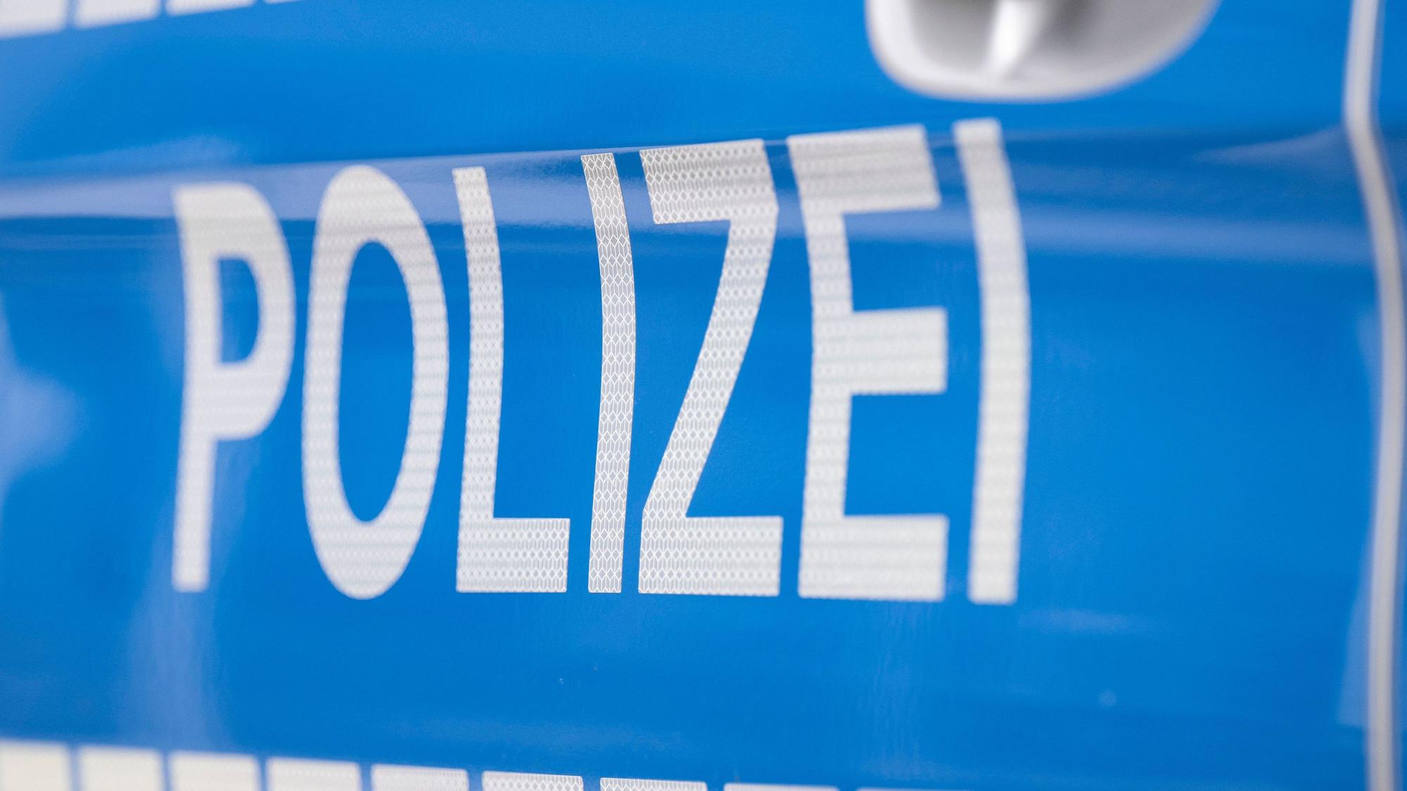 Der Schriftzug „Polizei“ ist auf einem Streifenwagen zu lesen.