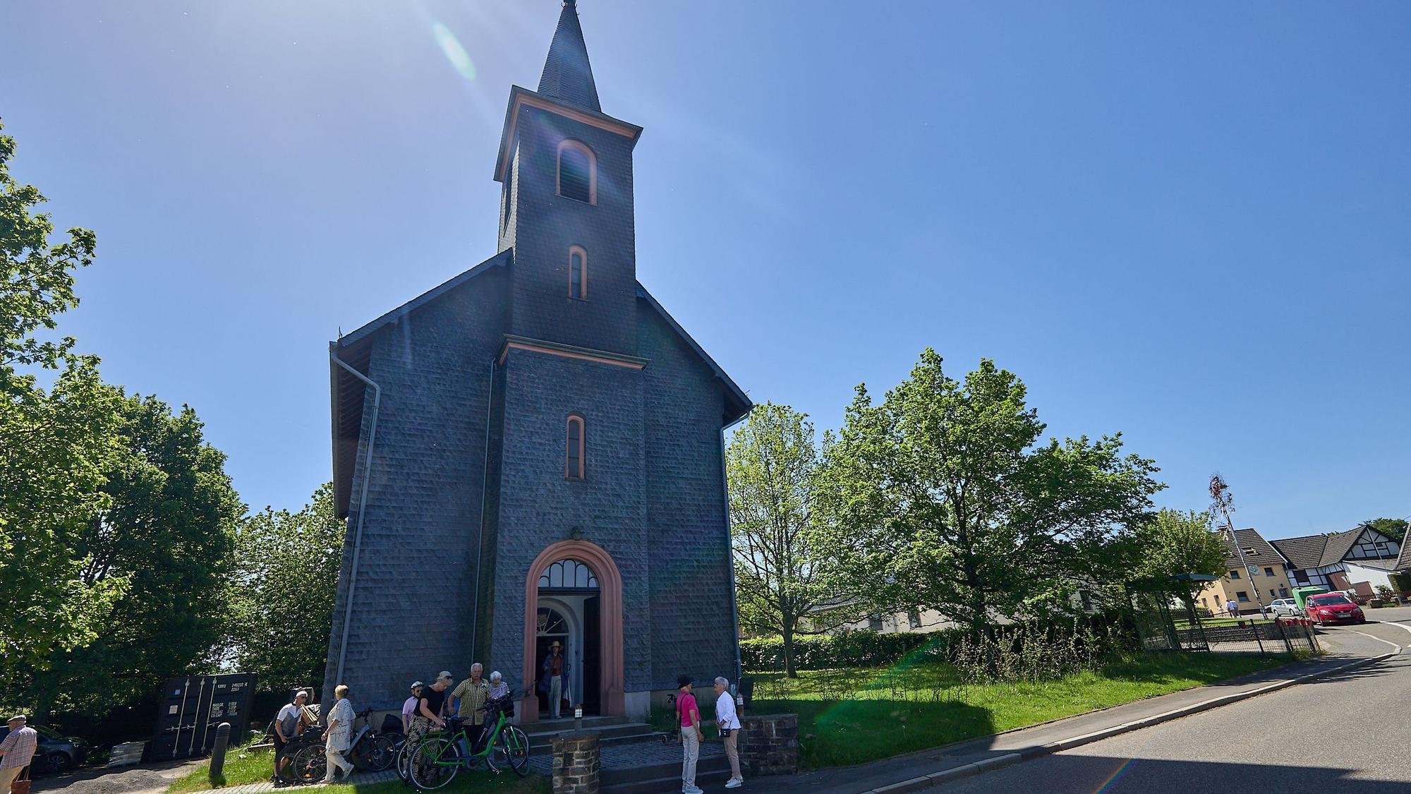 Vor der Kirche haben sich Besucher versammelt.