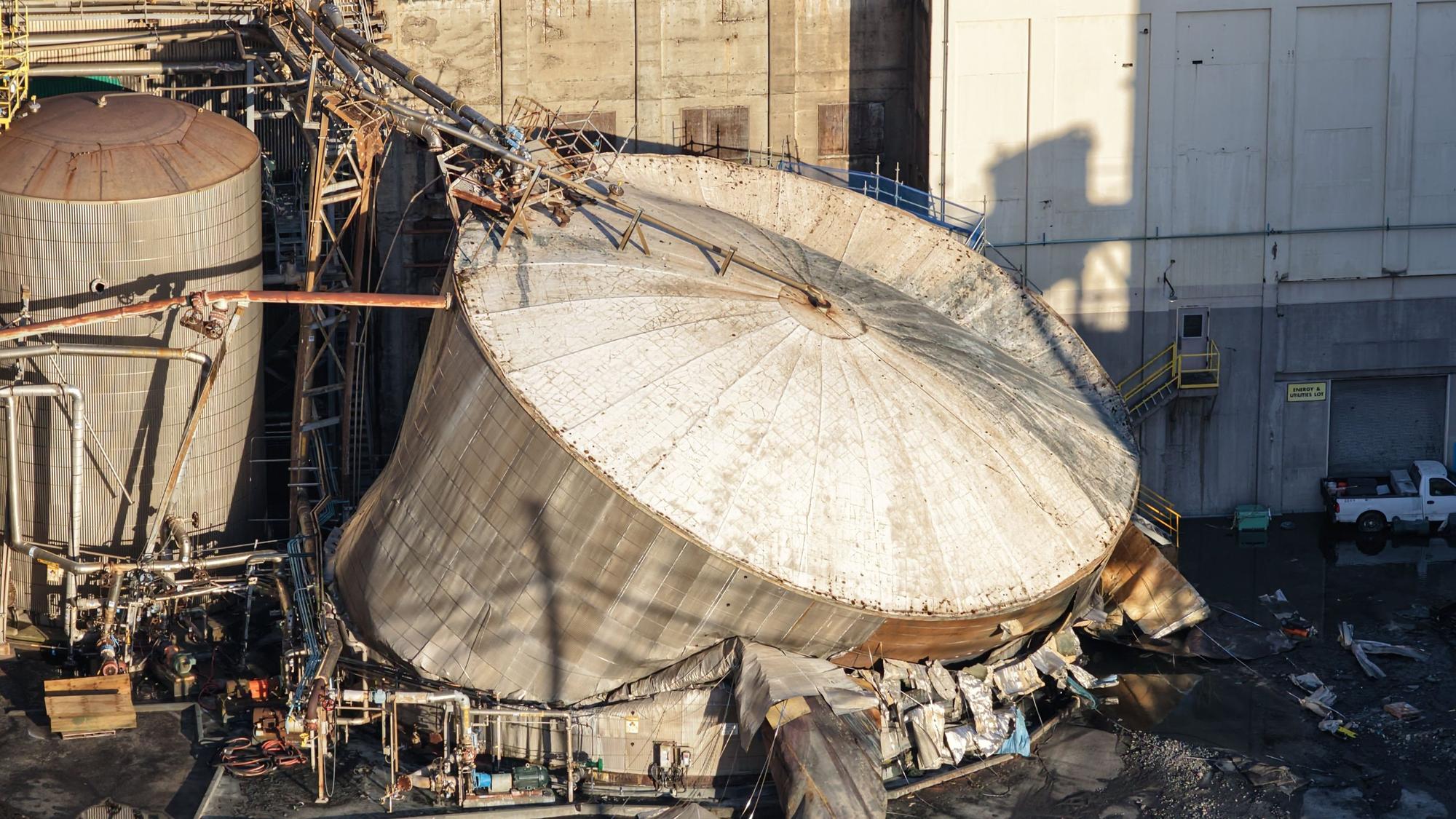 Schäden bei Nippon Dynawave Packaging Co. nach der Implosion eines Tanks mit gefährlicher Flüssigkeit.
