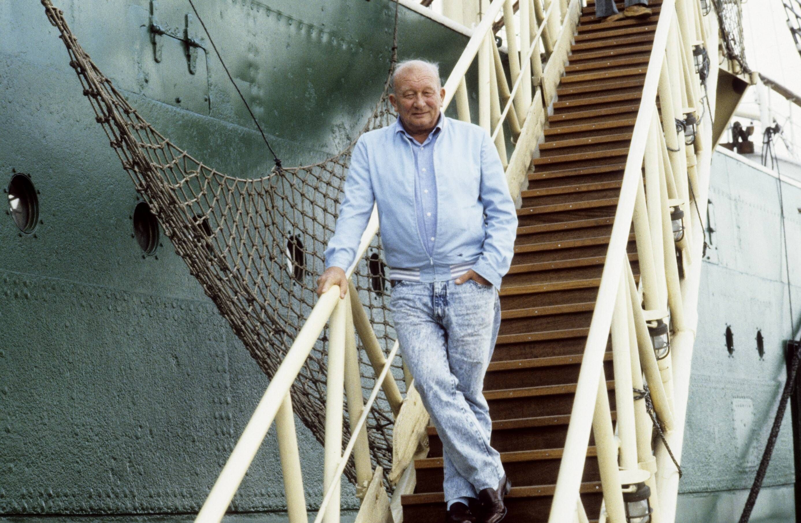 James Krüss steht vor einem Segelschiff