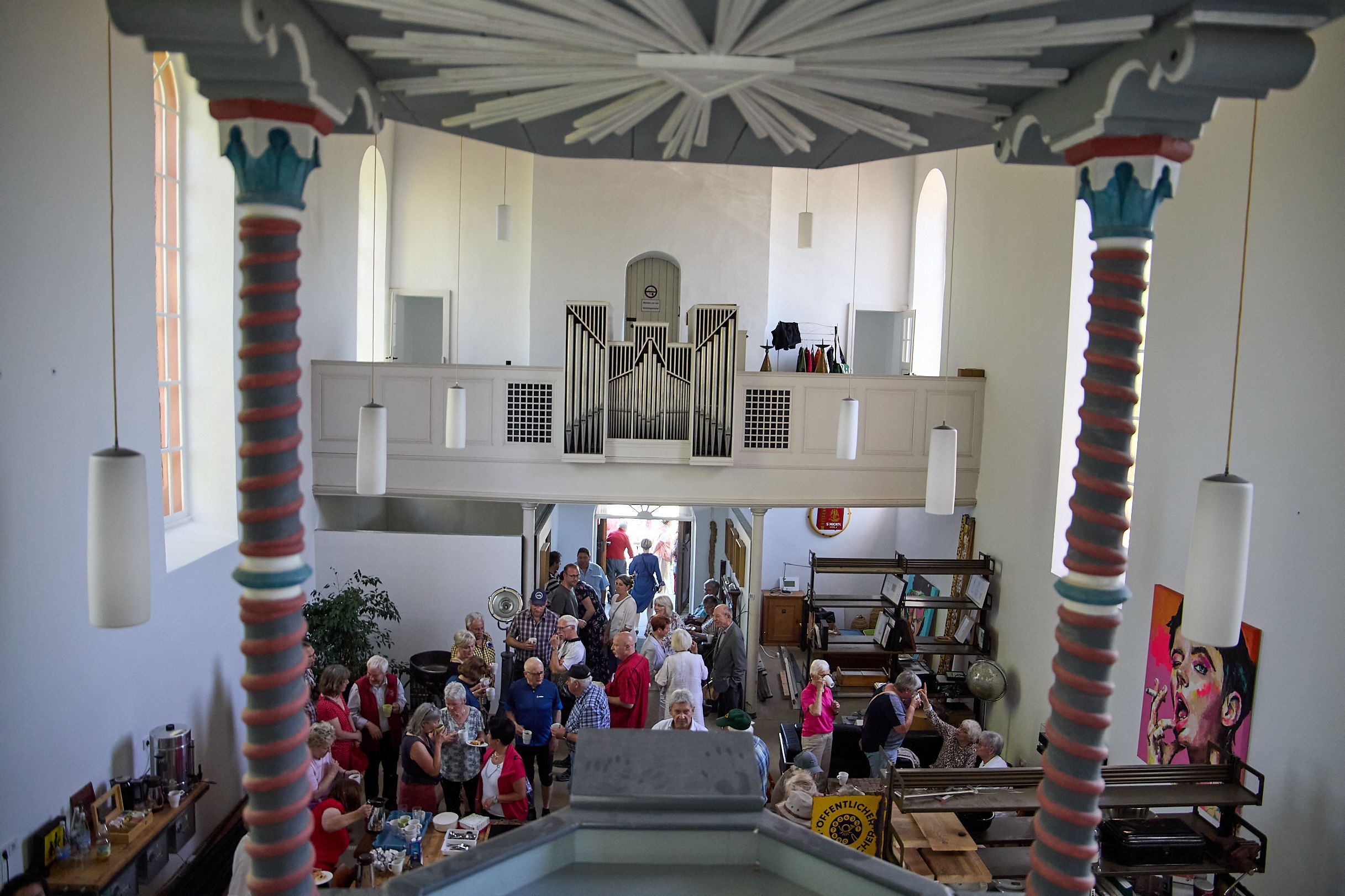 Blick von oben in die Kirche, im Vordergrund sind die Besucher zu sehen, im Hintergrund die Orgelempore.