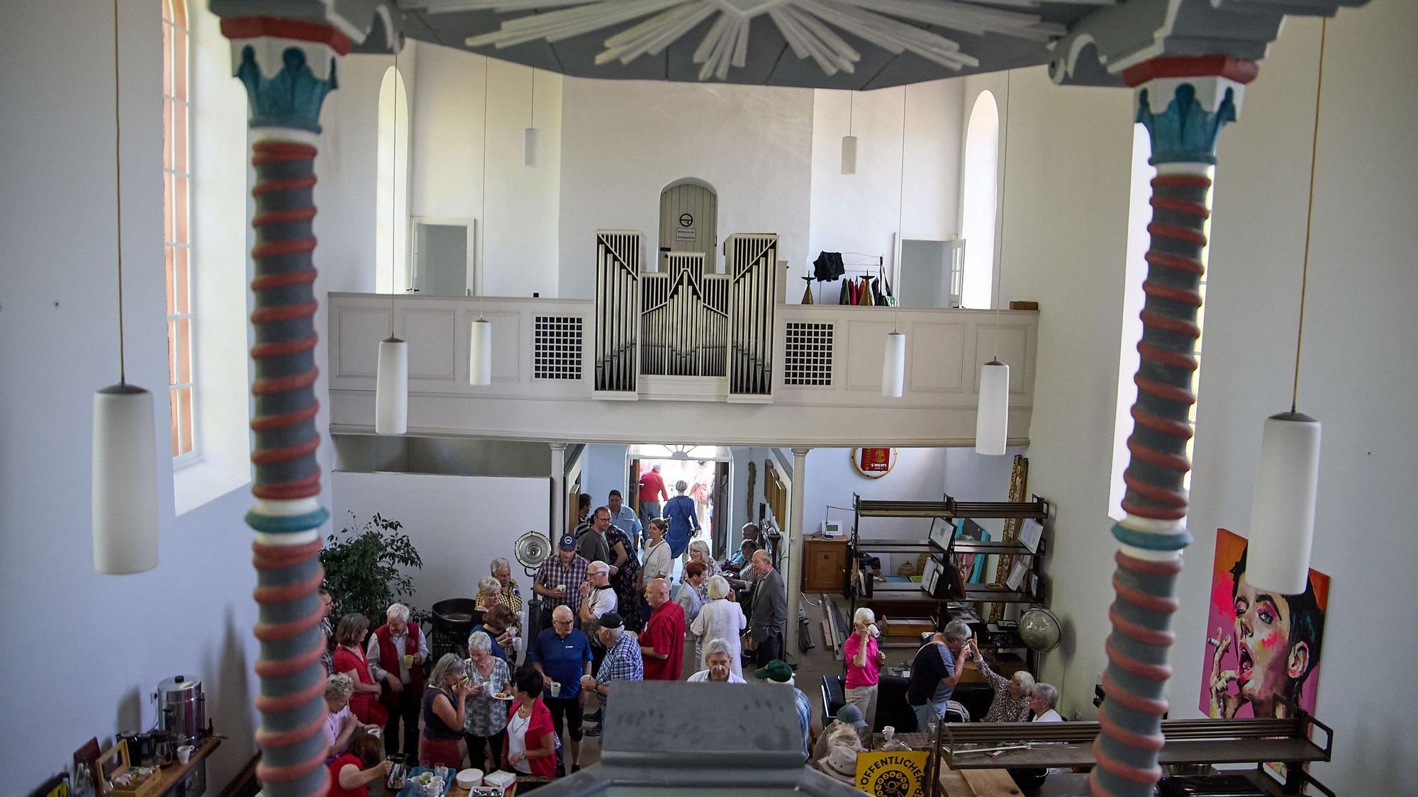 Blick von oben in die Kirche, im Vordergrund sind die Besucher zu sehen, im Hintergrund die Orgelempore.
