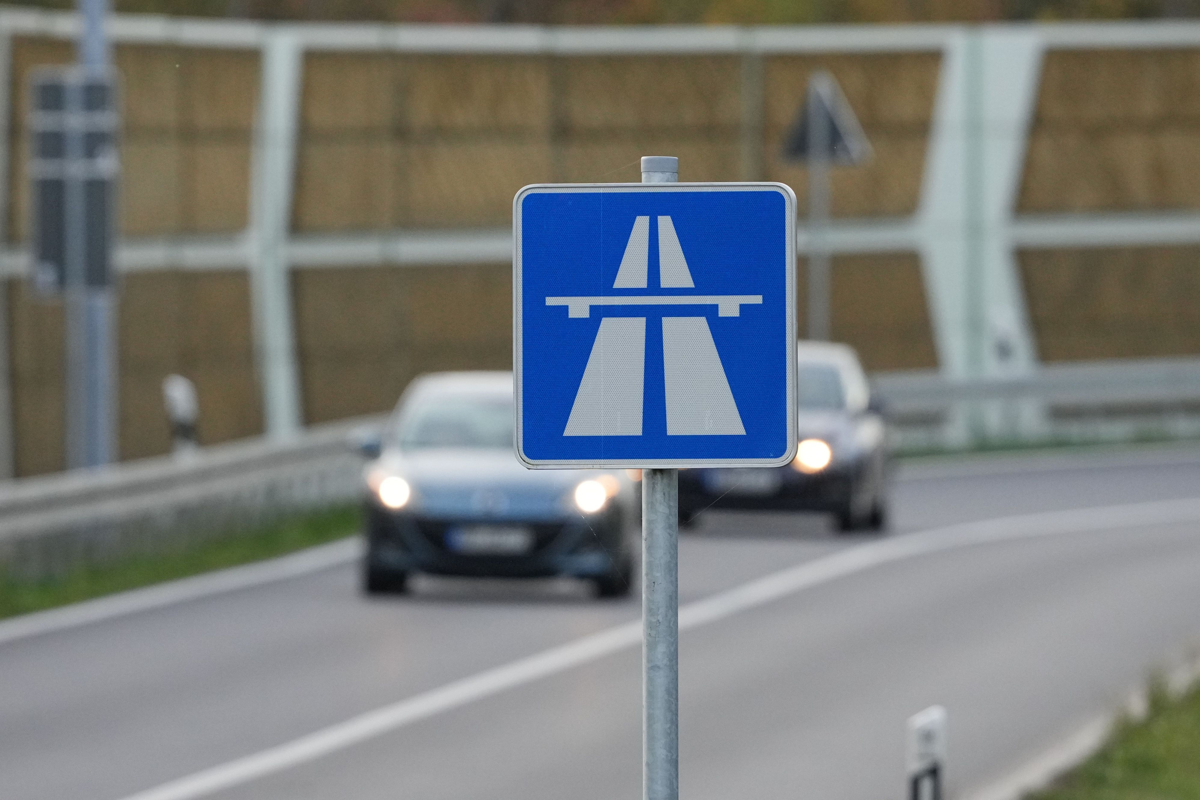 Das Foto zeigt ein Autobahn-Schild, im Hintergrund befinden sich Fahrzeuge.