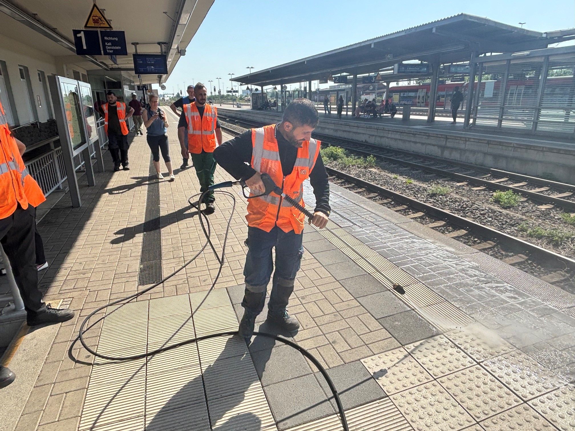 Mit einem Hochdruckreiniger säubert ein Mitarbeiter den Bahnsteig in Euskirchen.