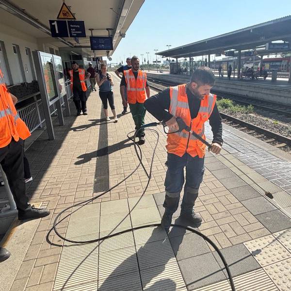 Mit einem Hochdruckreiniger säubert ein Mitarbeiter den Bahnsteig in Euskirchen.