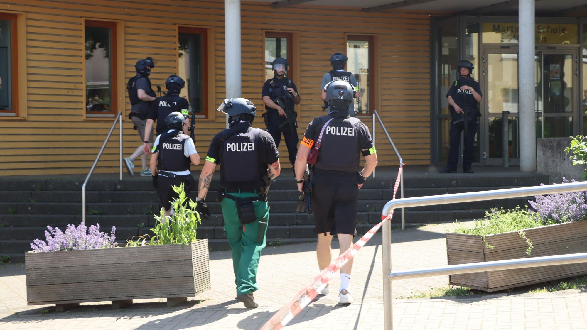 Vor der Heinrich-Böll-Gesamtschule in Merten positionierten sich Polizisten mit Waffen im Anschlag und durchsuchten das Gelände.