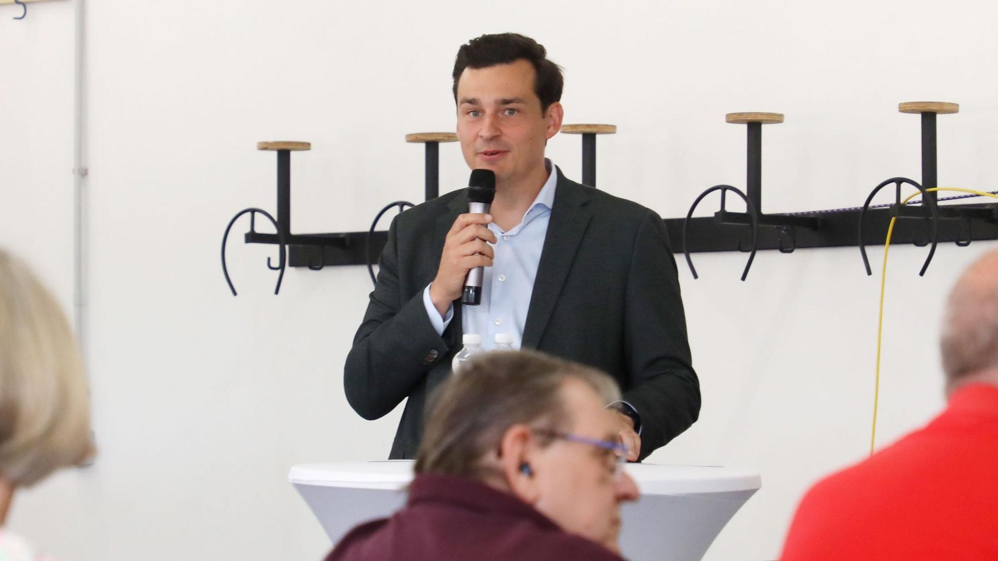 Bürgermeister Marcel Kreutz spricht bei der Infoveranstaltung in ein Mikro.
