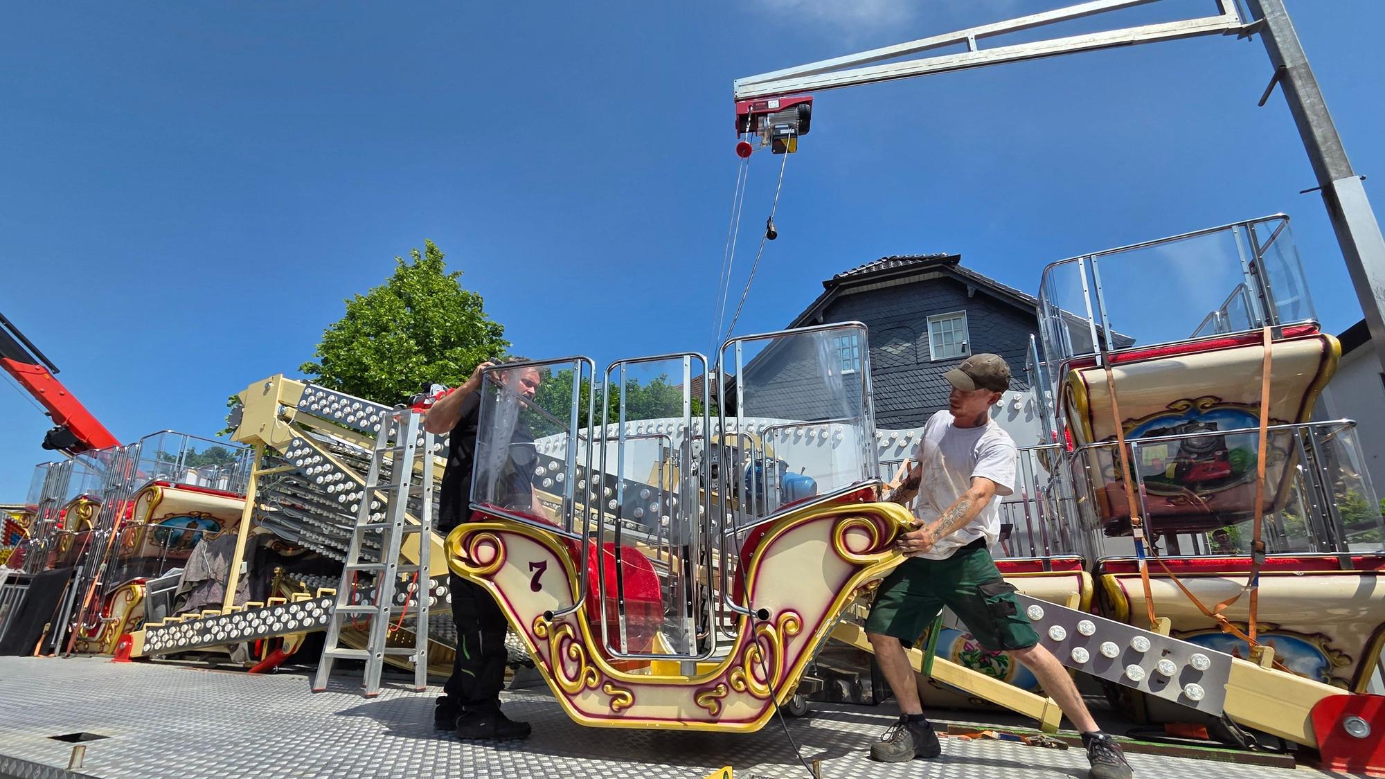 Christian Thiliant (links) und sein Mitarbeiter Michael Junge bereiten auf dem Kirmesplatz an der Hochstraße in Waldbröl die Gondeln des Riesenrad „Roue Belle“ für die spätere Montage vor.