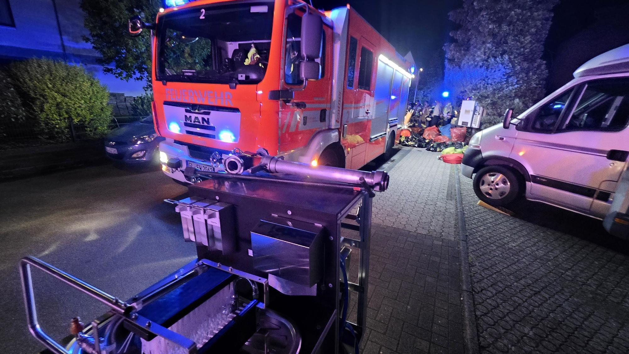 Ein Einsatzfahrzeug der Feuerwehr steht mit Blaulicht auf einer Straße in Bergisch Gladbach-Kippekausen.