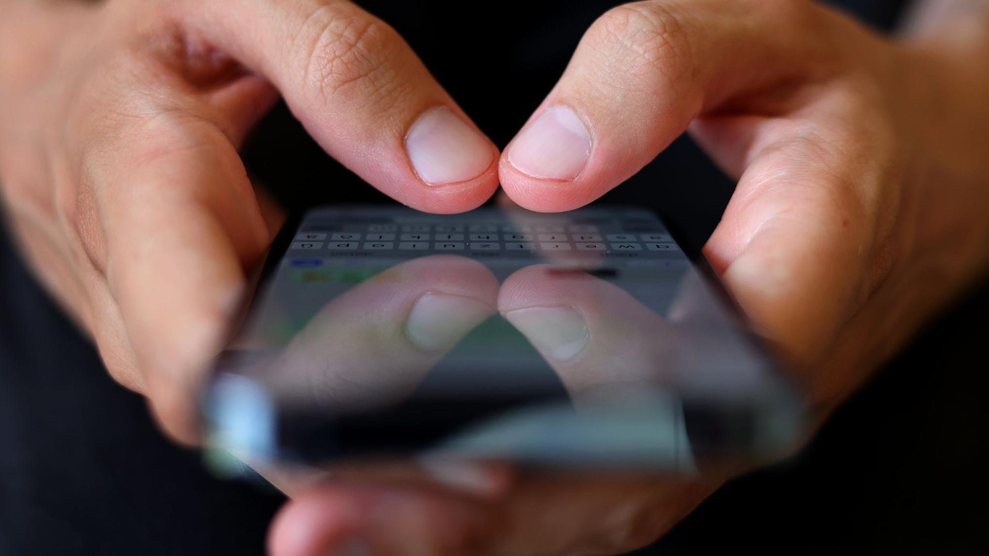 Ein Mann tippt auf einem Smartphone