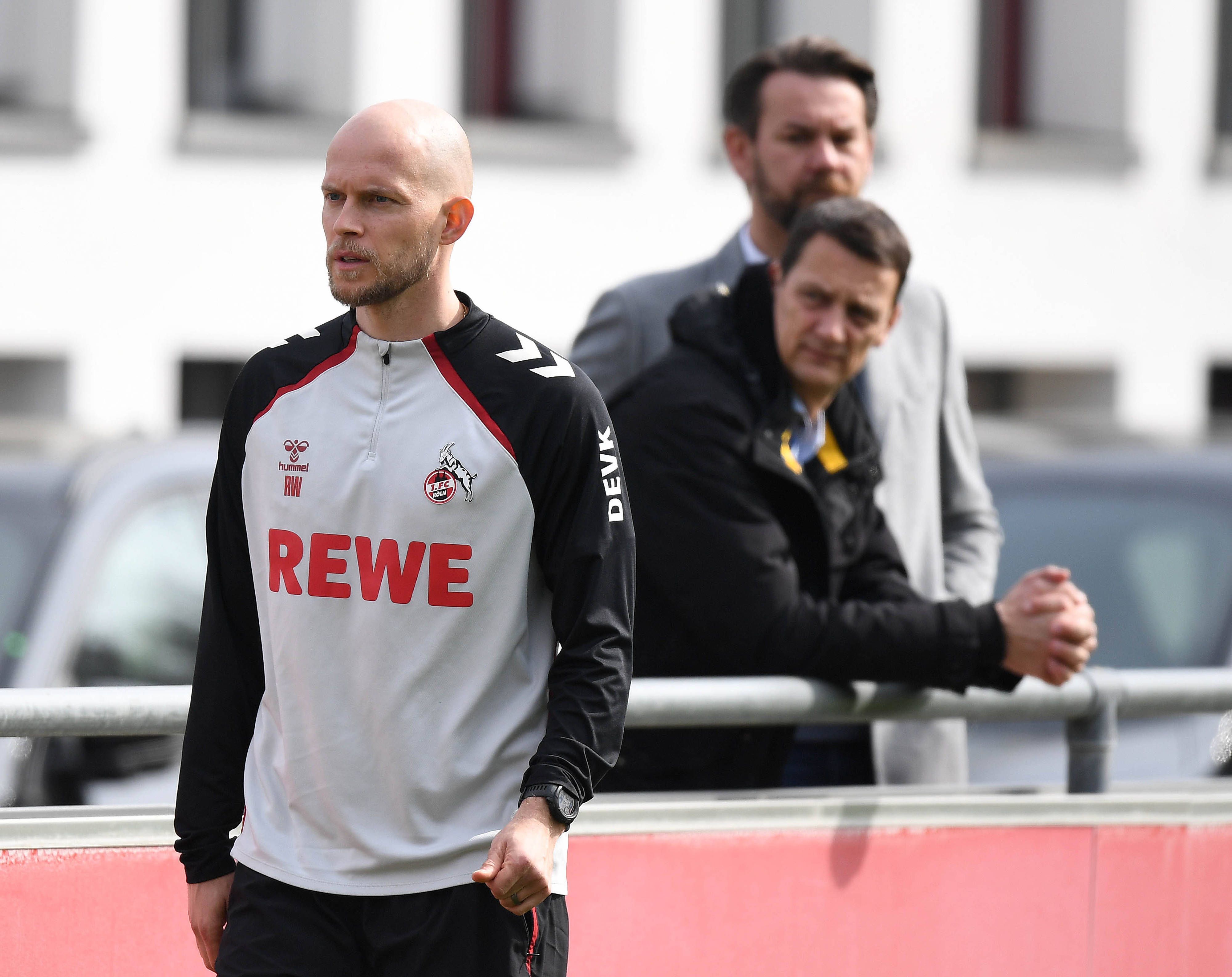 René Wagner auf dem Trainingsplatz, dahinter stehen Ulf Sobek und Thomas Kessler an der Bande.