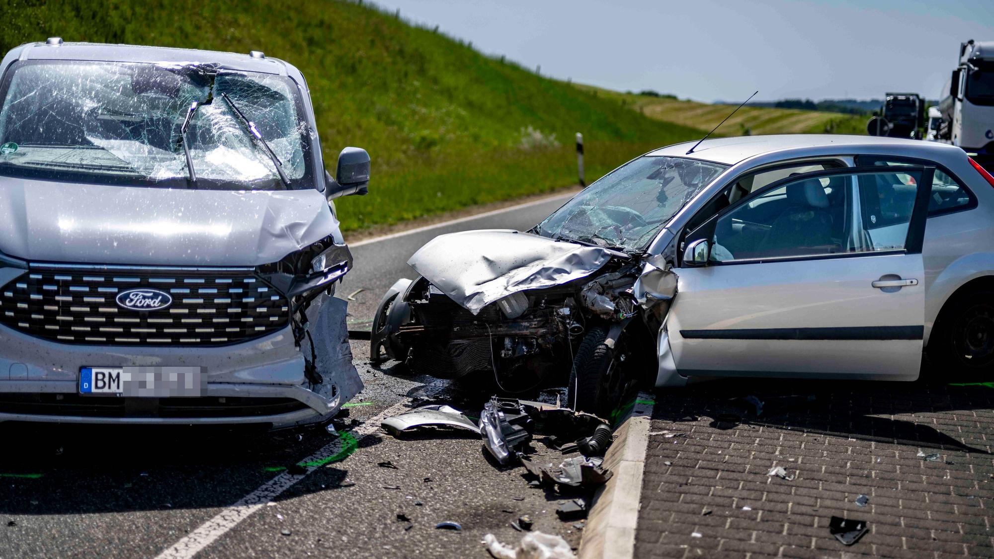 Das Bild zeigt die zwei stark beschädigten Autos nach dem Unfall auf der L115.