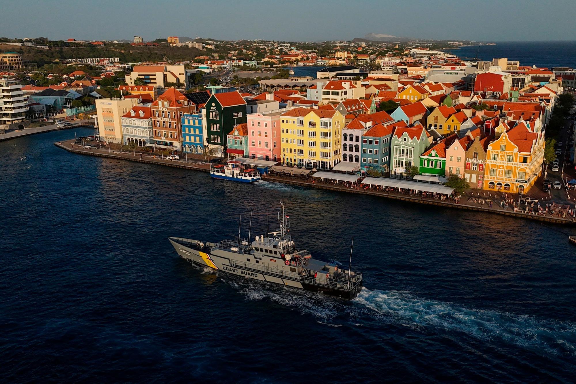 Curaçao, Willemstad: Ein Schiff der niederländisch-karibischen Küstenwache durchquert die St.-Anna-Bucht neben dem historischen Zentrum in Willemstad.