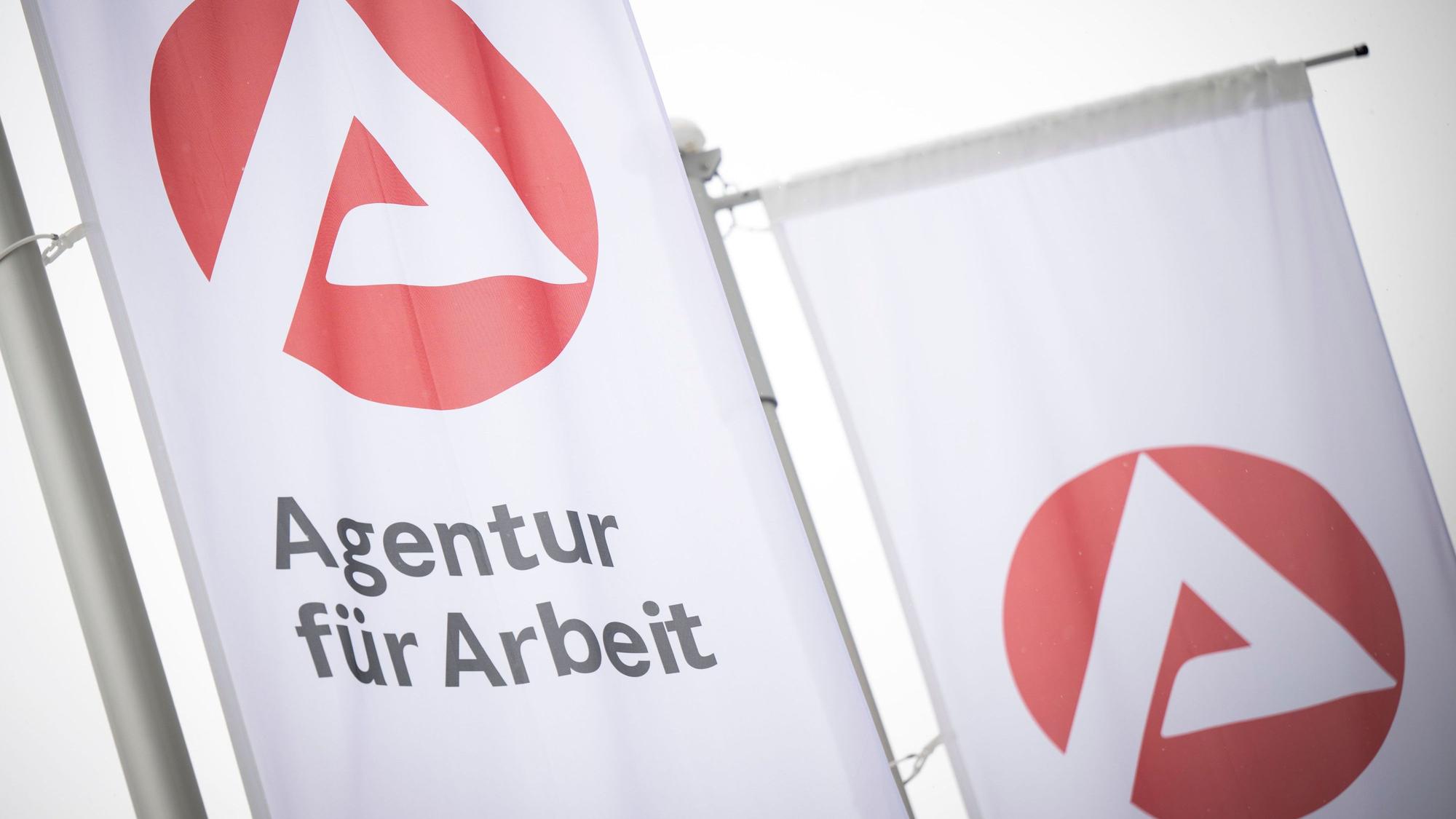 Fahnen mit dem Logo der Agentur für Arbeit wehen im Wind. (Symbolbild)