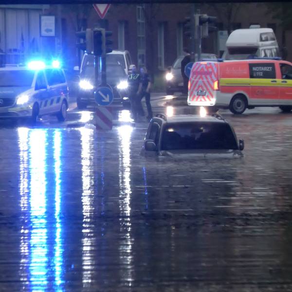 Ein Auto steht in Rheine in einer überfluteten Straße in einer Unterführung.