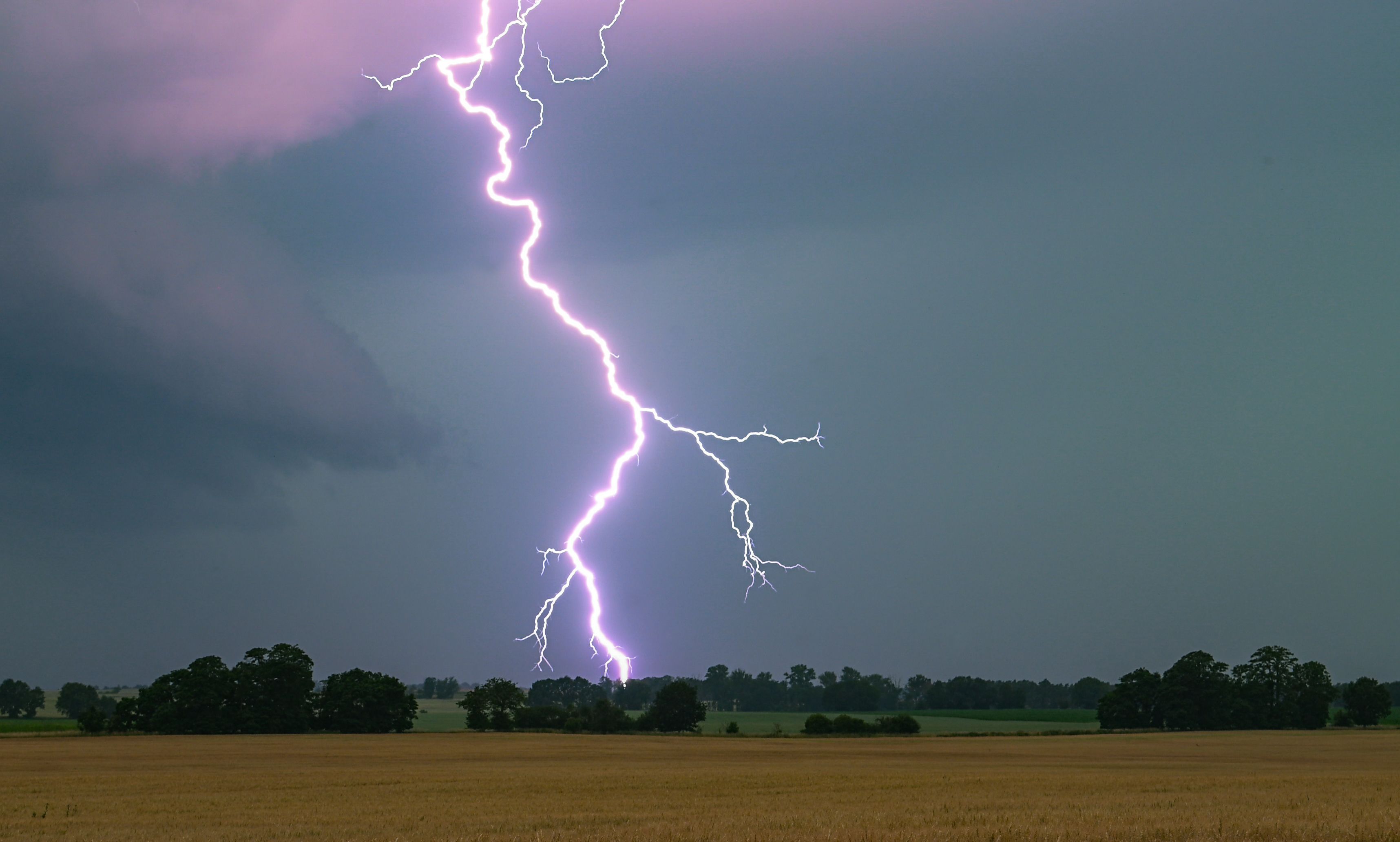 Ein Blitz leuchtet über einer Landschaft auf. (Symbolbild)
