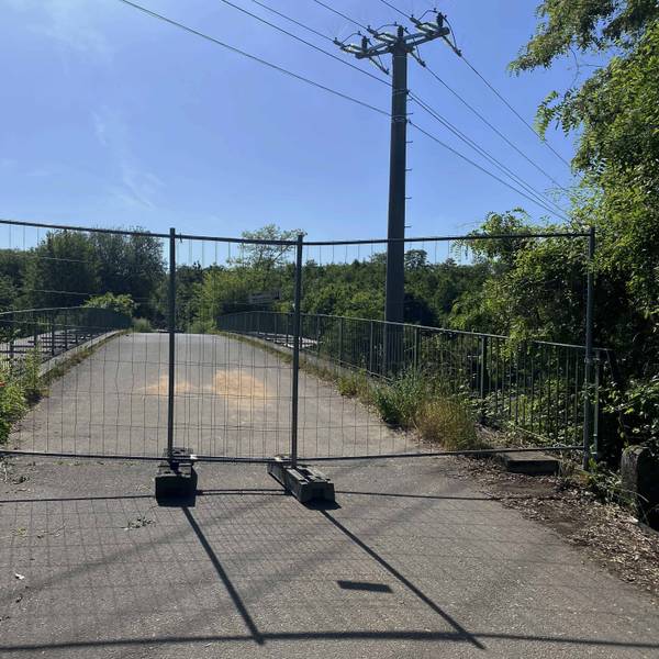 Auf dem Bild ist ein Bauzaun zu sehen, der eine Brücke absperrt.