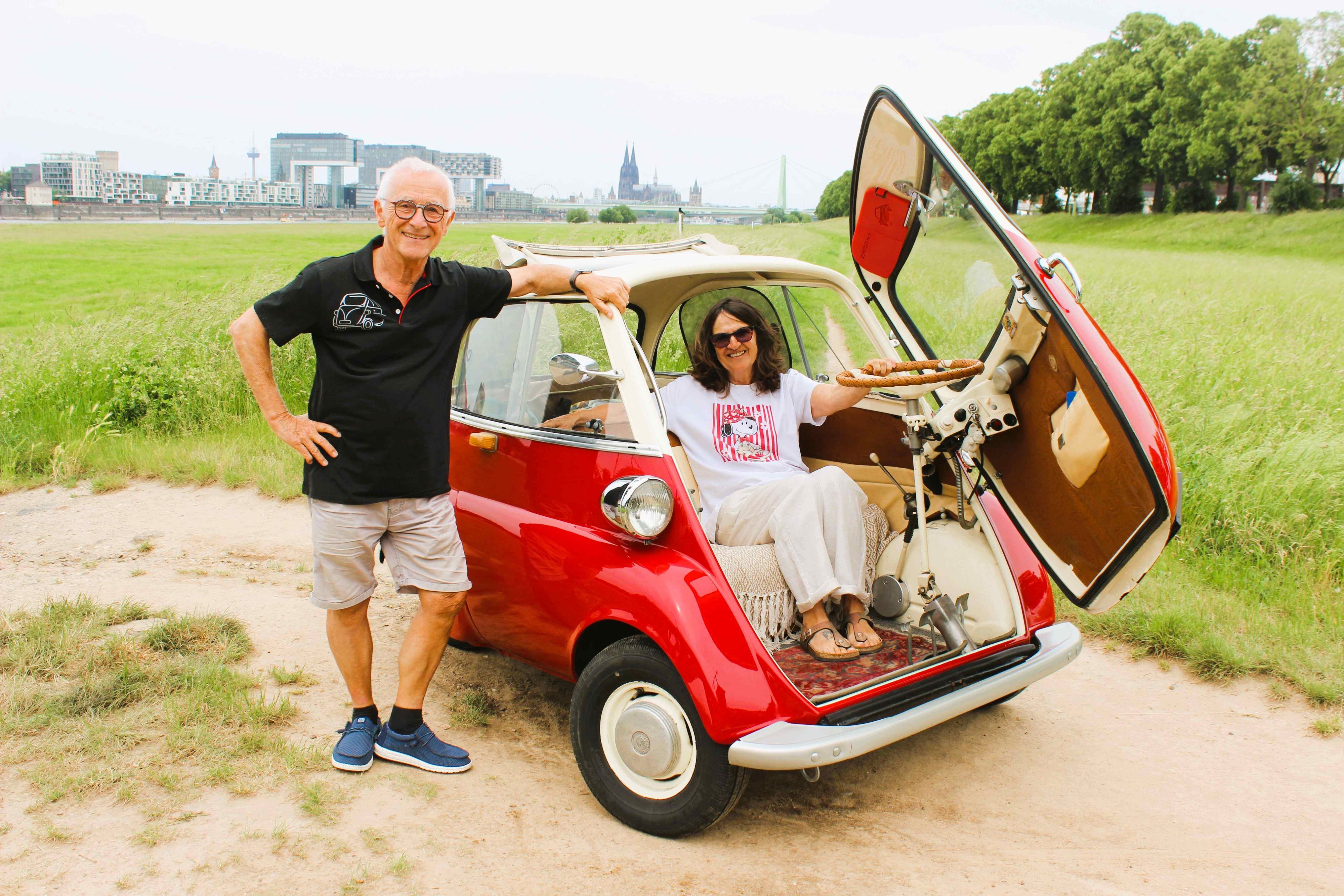 Karin Bernhart und Peter Schmidt mit ihrer Isetta auf den Poller Wiesen, im Hintergrund Rhein und Dom