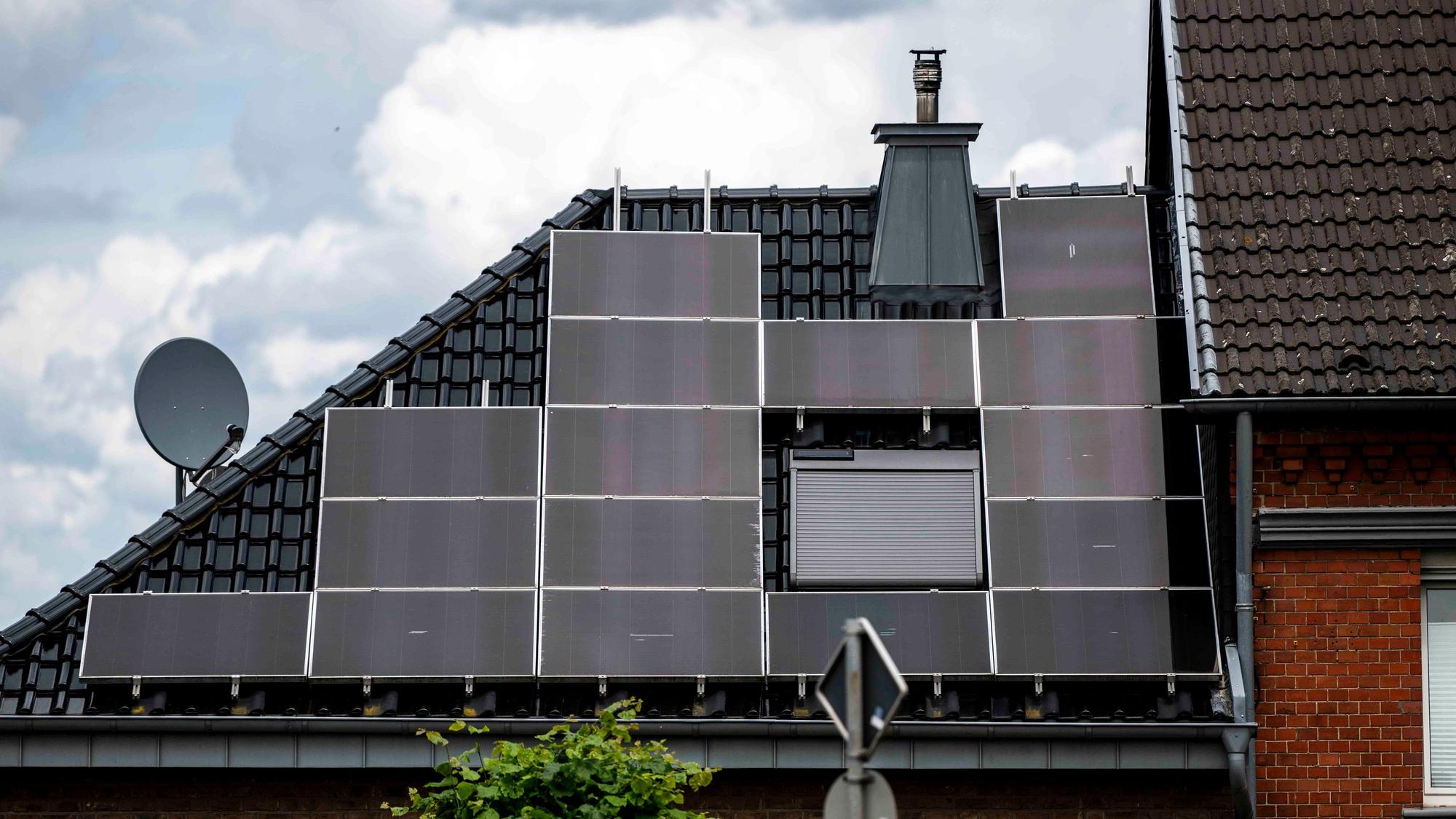 Auf einem Hausdach sind Solarpaneele angebracht.
