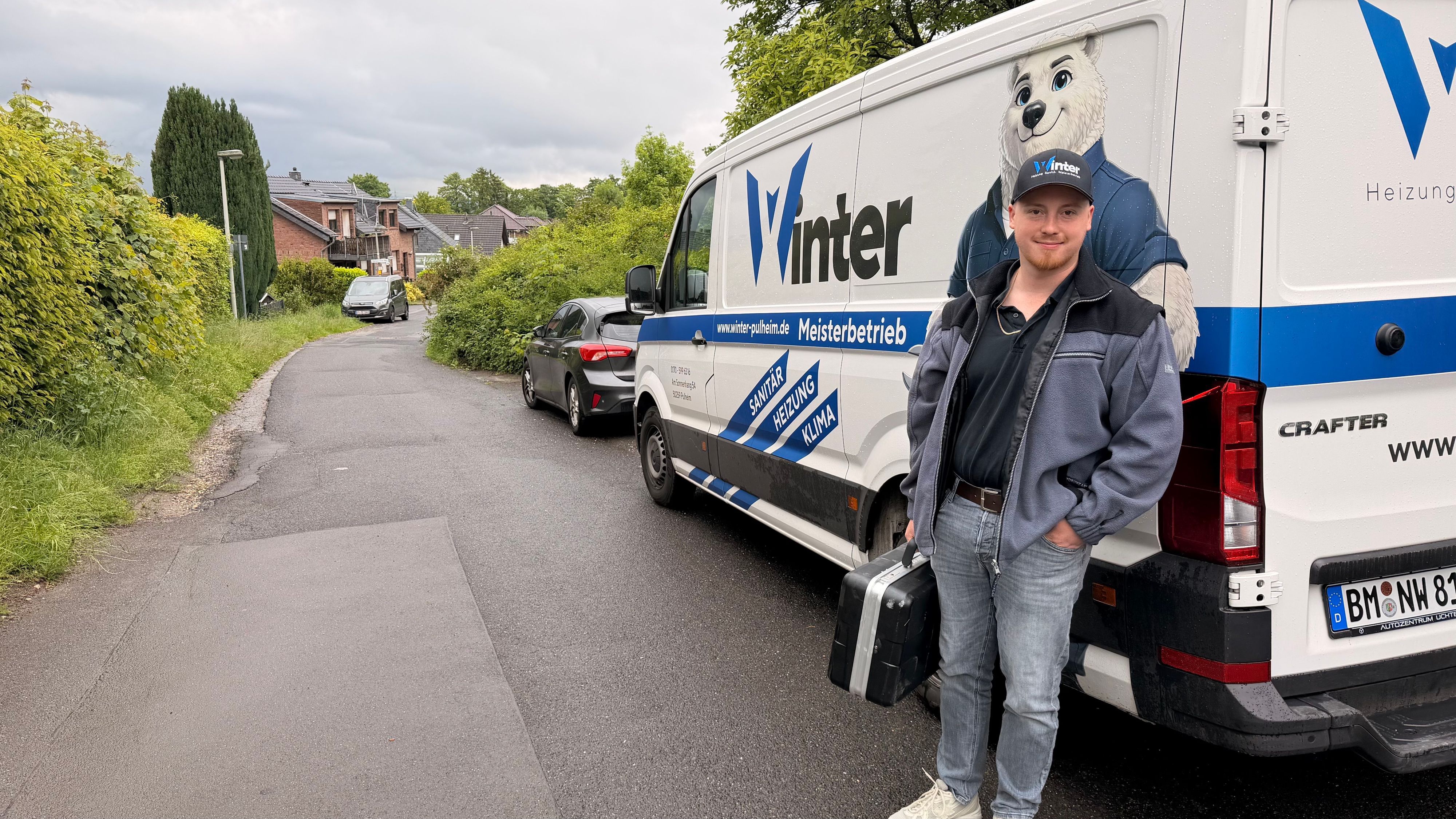 Ein Mann steht neben einem Transporter, auf dem ein Eisbär zu sehen ist.