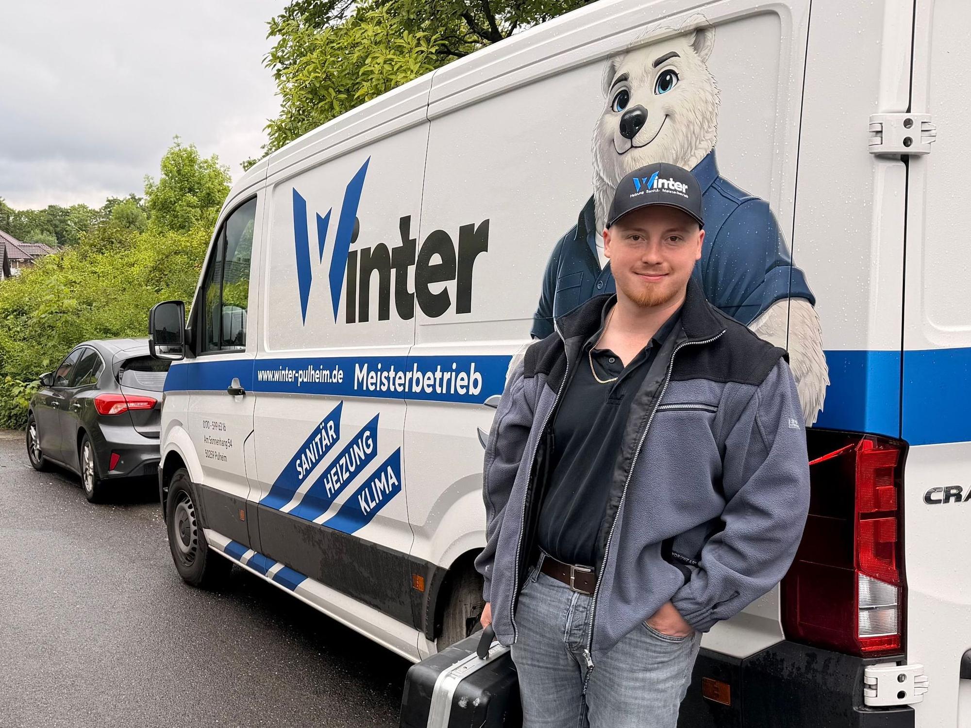 Ein Mann steht neben einem Transporter, auf dem ein Eisbär zu sehen ist.
