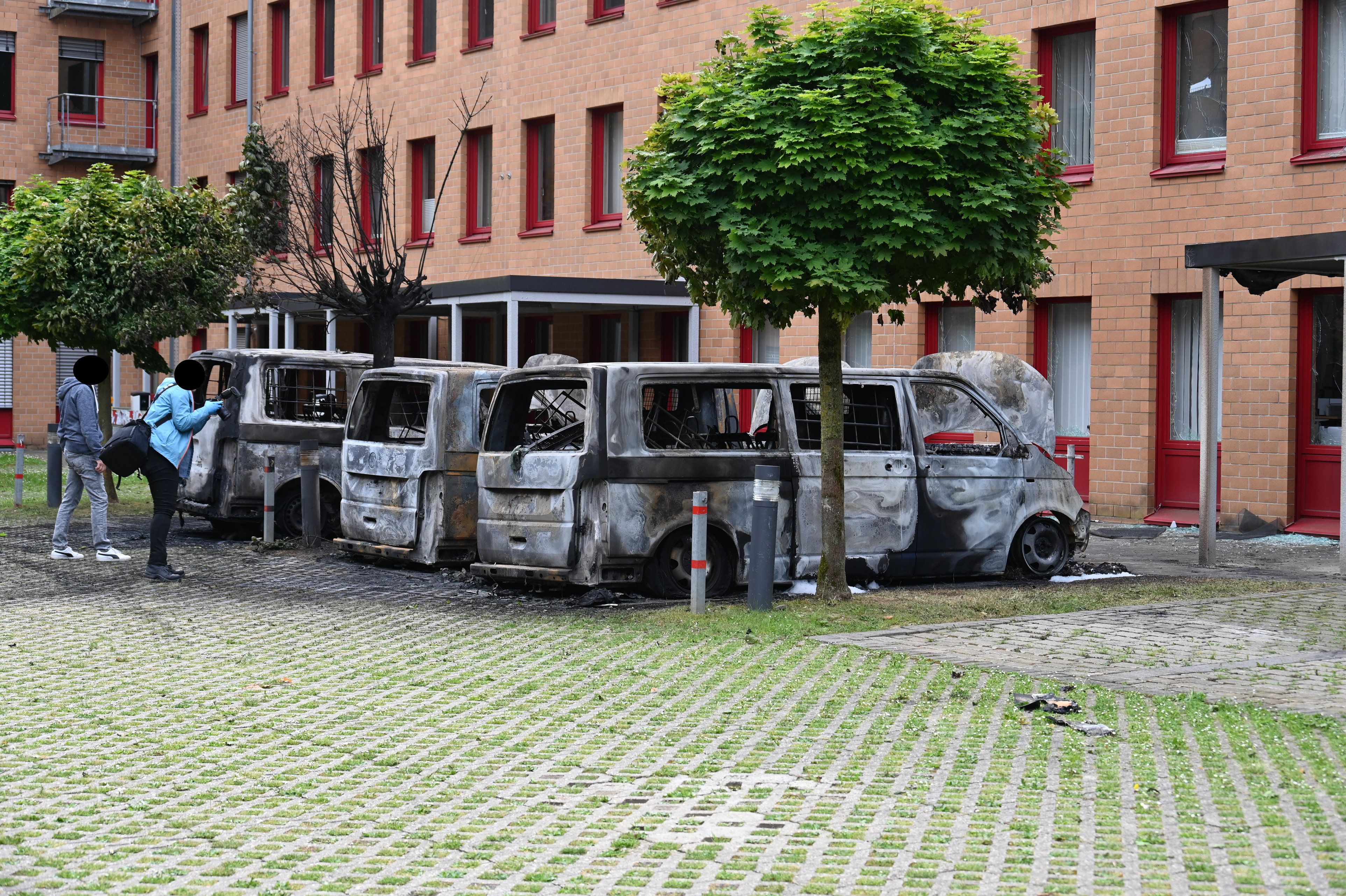Das Bild zeigt ausbrannte Kleinbusse.