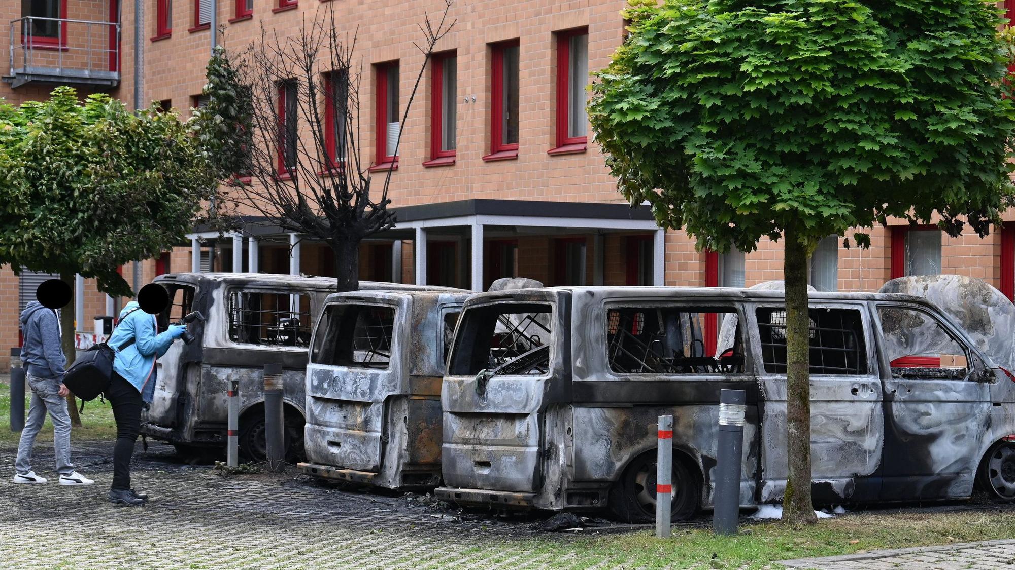 Das Bild zeigt ausbrannte Kleinbusse.