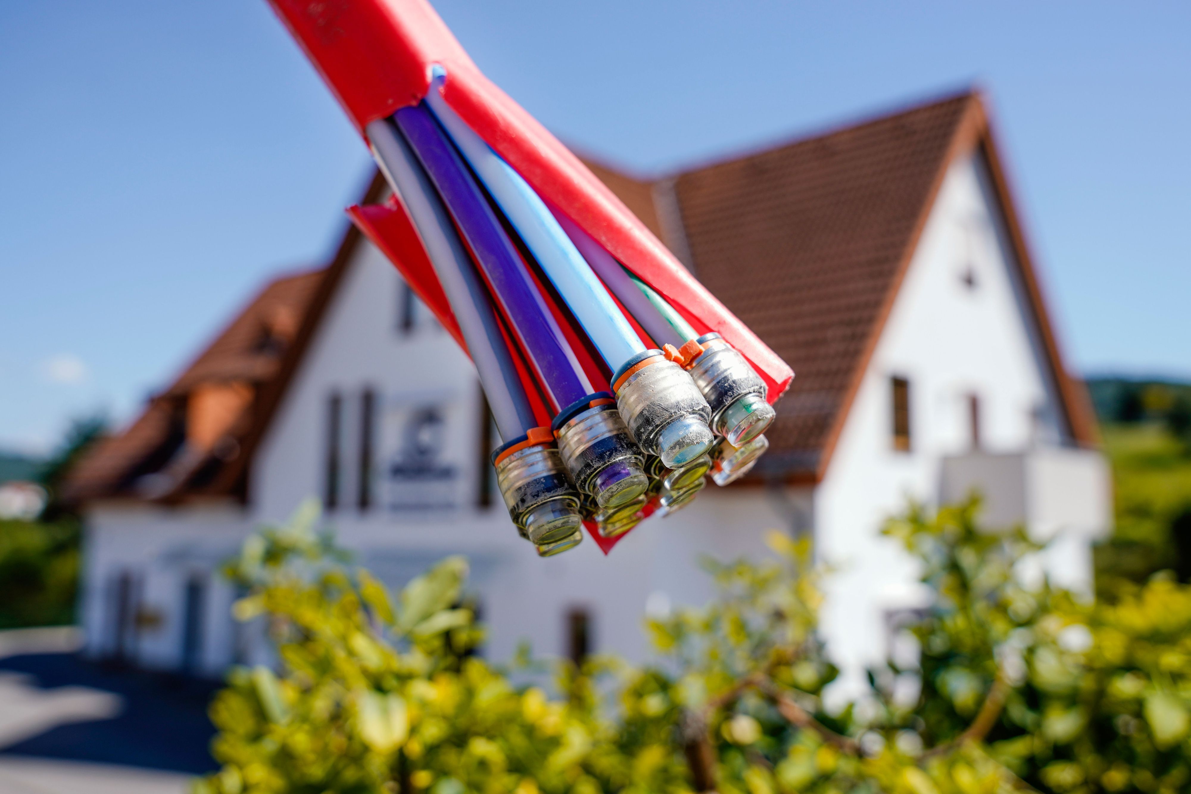 Bündel mit Umhüllungen für Glasfaserkabel vor einem Wohnhaus