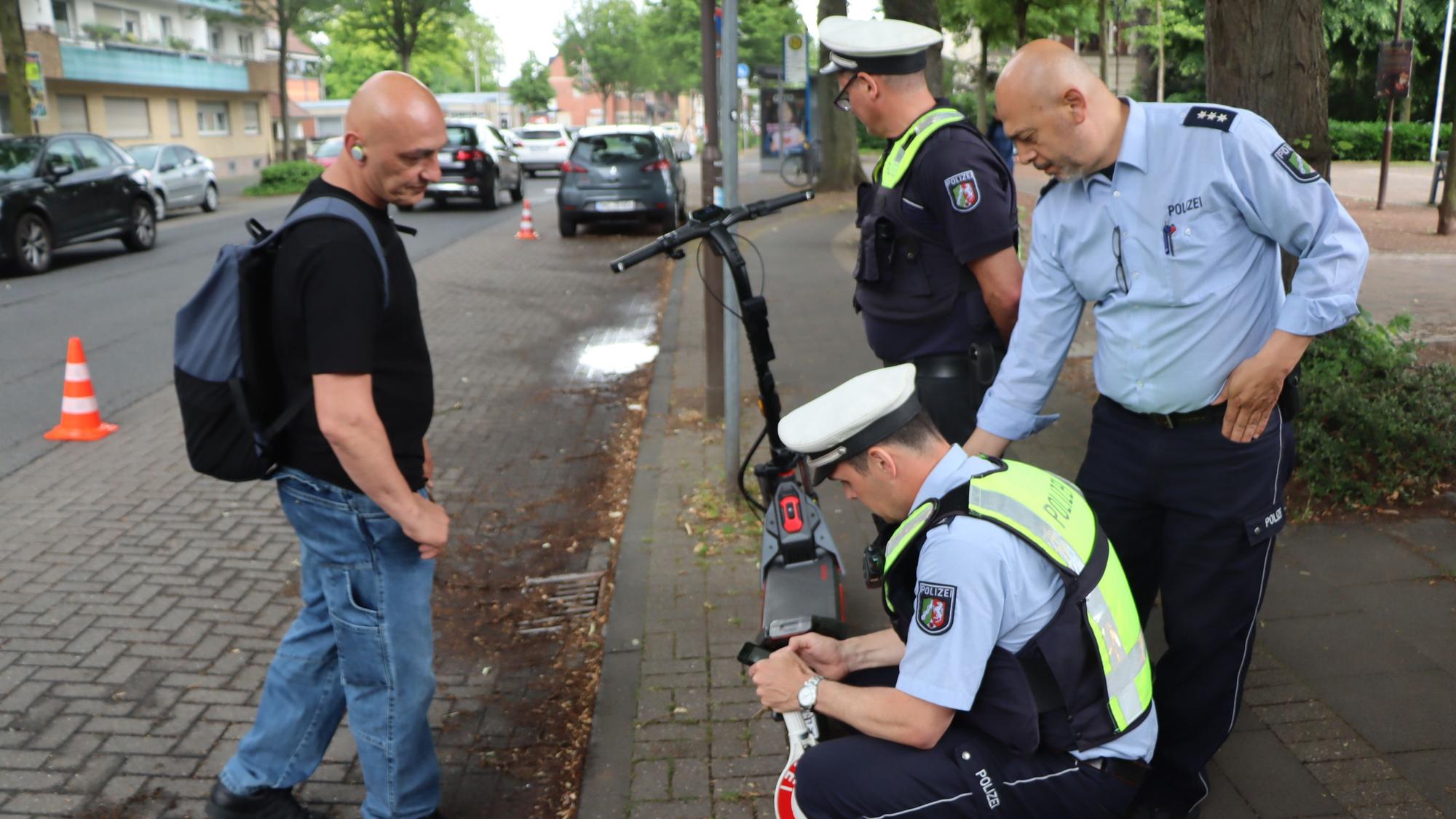Das Bild zeigt Polizisten an einem E-Scooter.