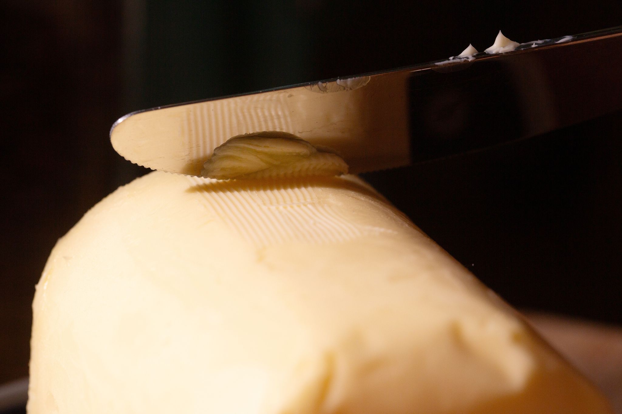 Ein Messer streicht über ein Stück Butter
