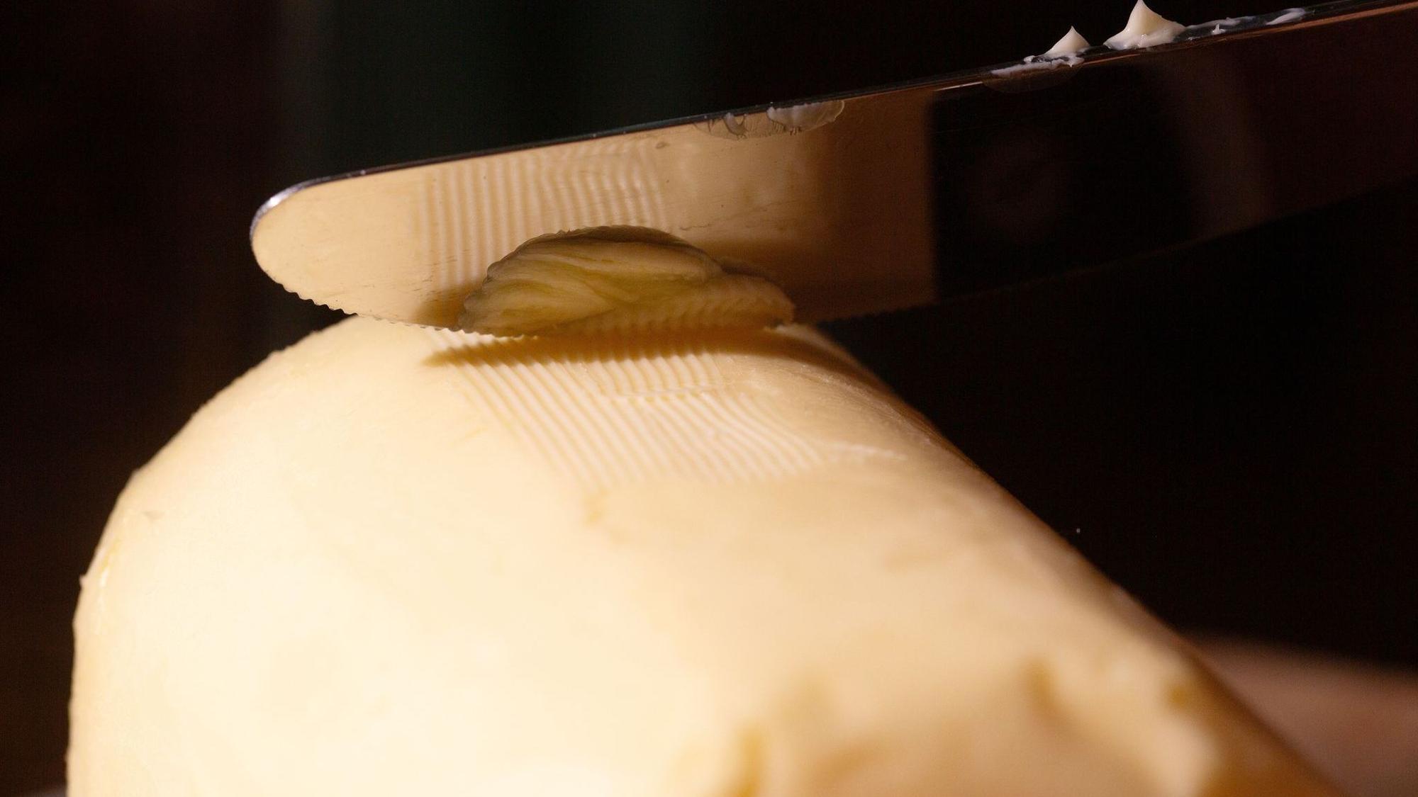 Ein Messer streicht über ein Stück Butter