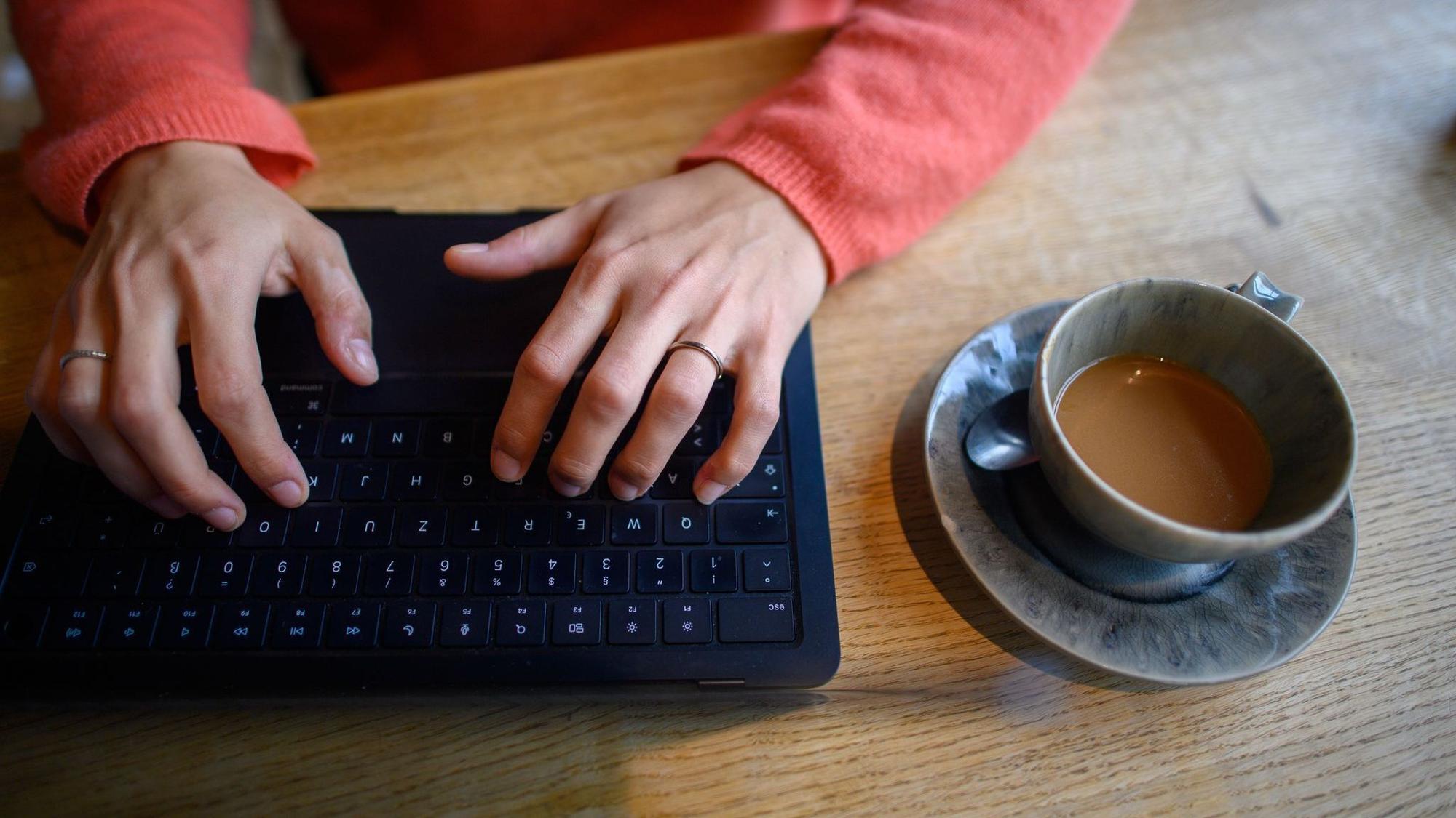 Eine Frau nutzt ihren Laptop in einem Café