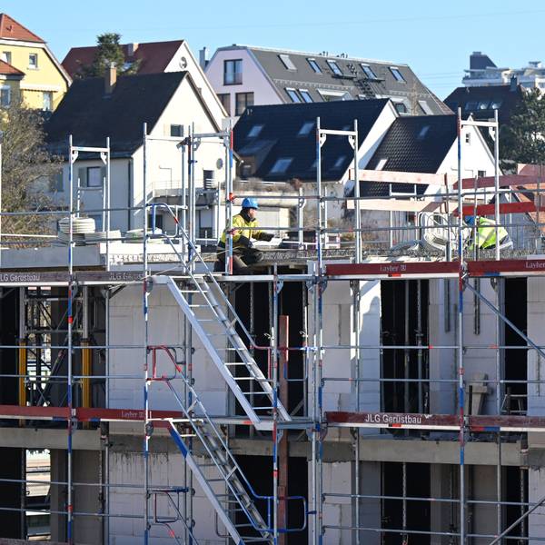 Auf einer Baustelle für Wohnungen und Sozialwohnungen arbeiten Bauarbeiter am Rohbau.
