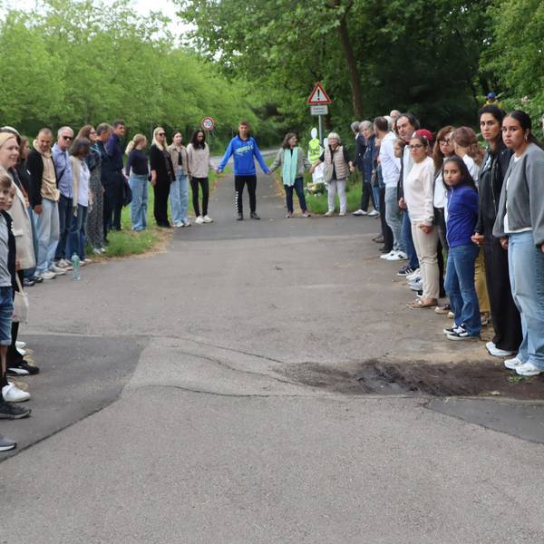 Zu sehen sind Menschen, die sich an den Händen halten.