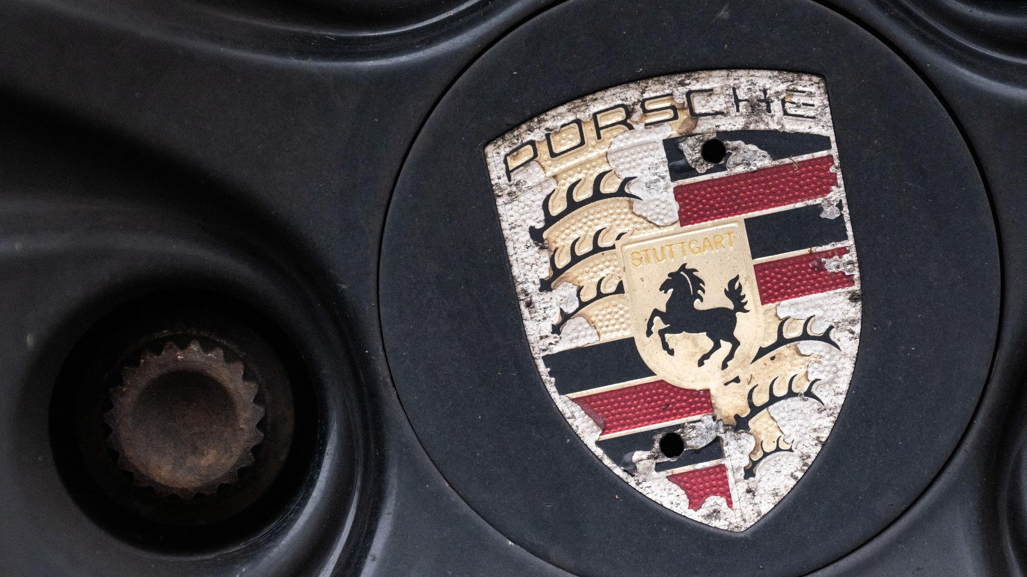 Ein Logo der Porsche AG ist an einer älteren Felge eines Porsche Fahrzeuges zu sehen