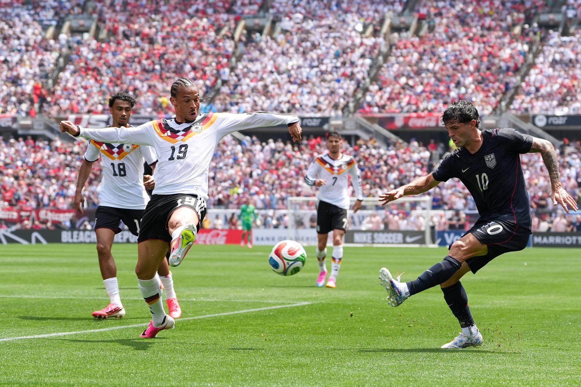 Christian Pulisic schießt den Ball gegen Leroy Sané.