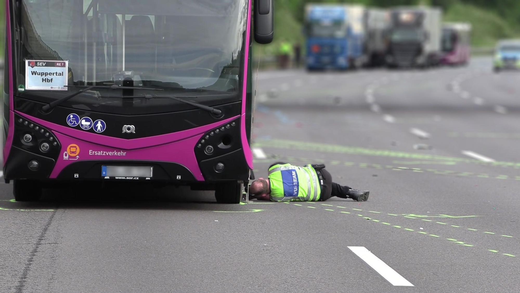 Ein Polizist des Verkehrsunfallaufnahmeteams fotografiert unter einem Bus. Ein Motorradfahrer ist am frühen Samstagmorgen auf der A3 gestürzt und von einem Bus überrollt worden. Der Mann ist dabei tödlich verletzt worden.