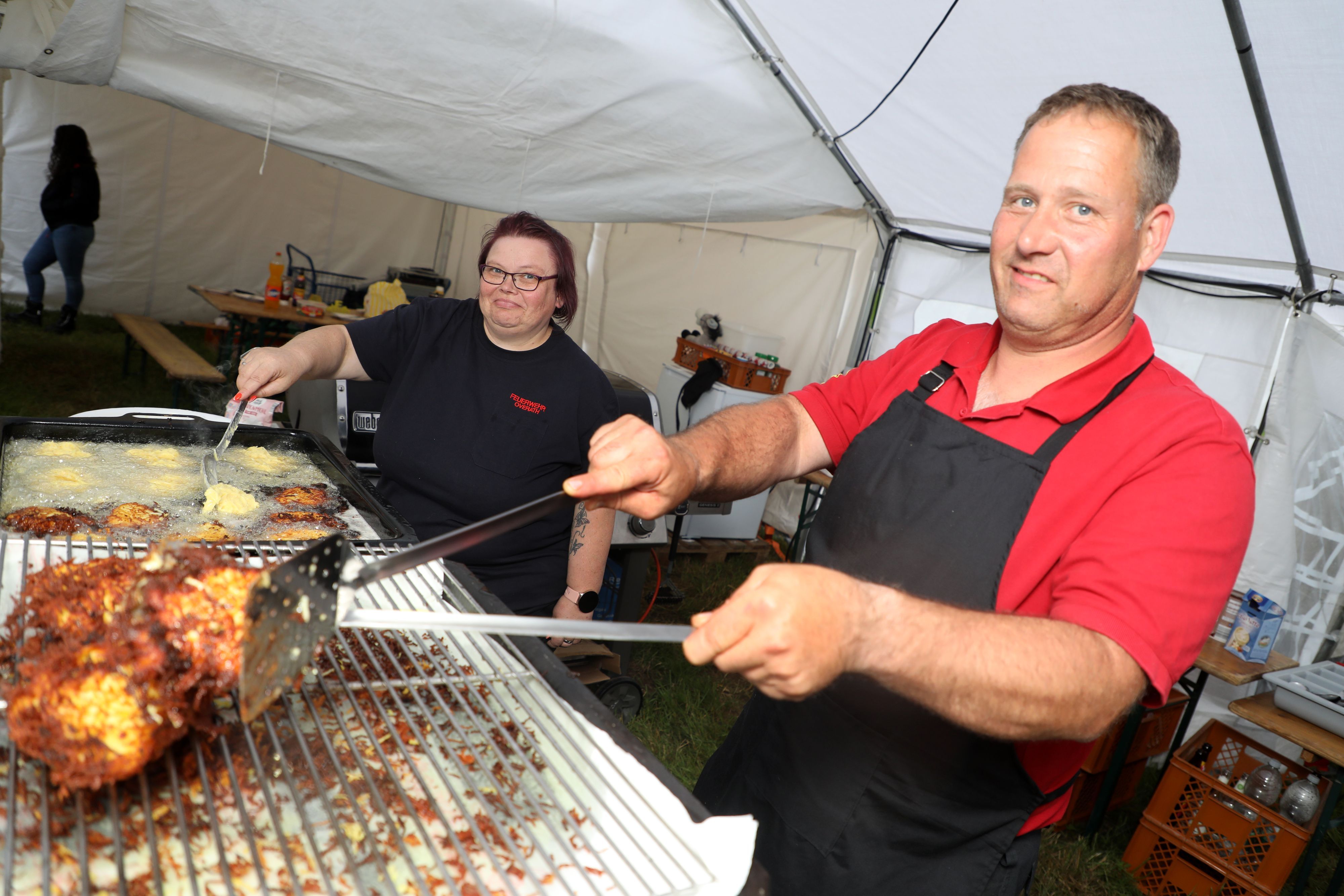 Overaths Stadtjugendfeuerwehrwart Thorsten Merkel und seine Frau Kerstin braten Reibekuchen.