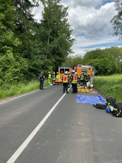 Ein verunfalltes Auto steht am Straßenrand.
