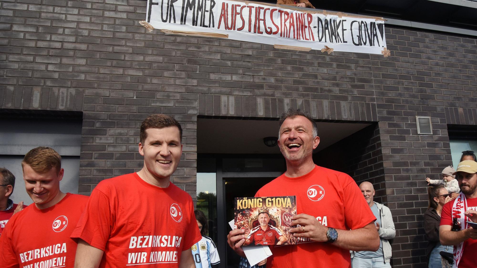 Ein Trainer zeigt ein Buch, das er von seiner Mannschaft bekommen hat.