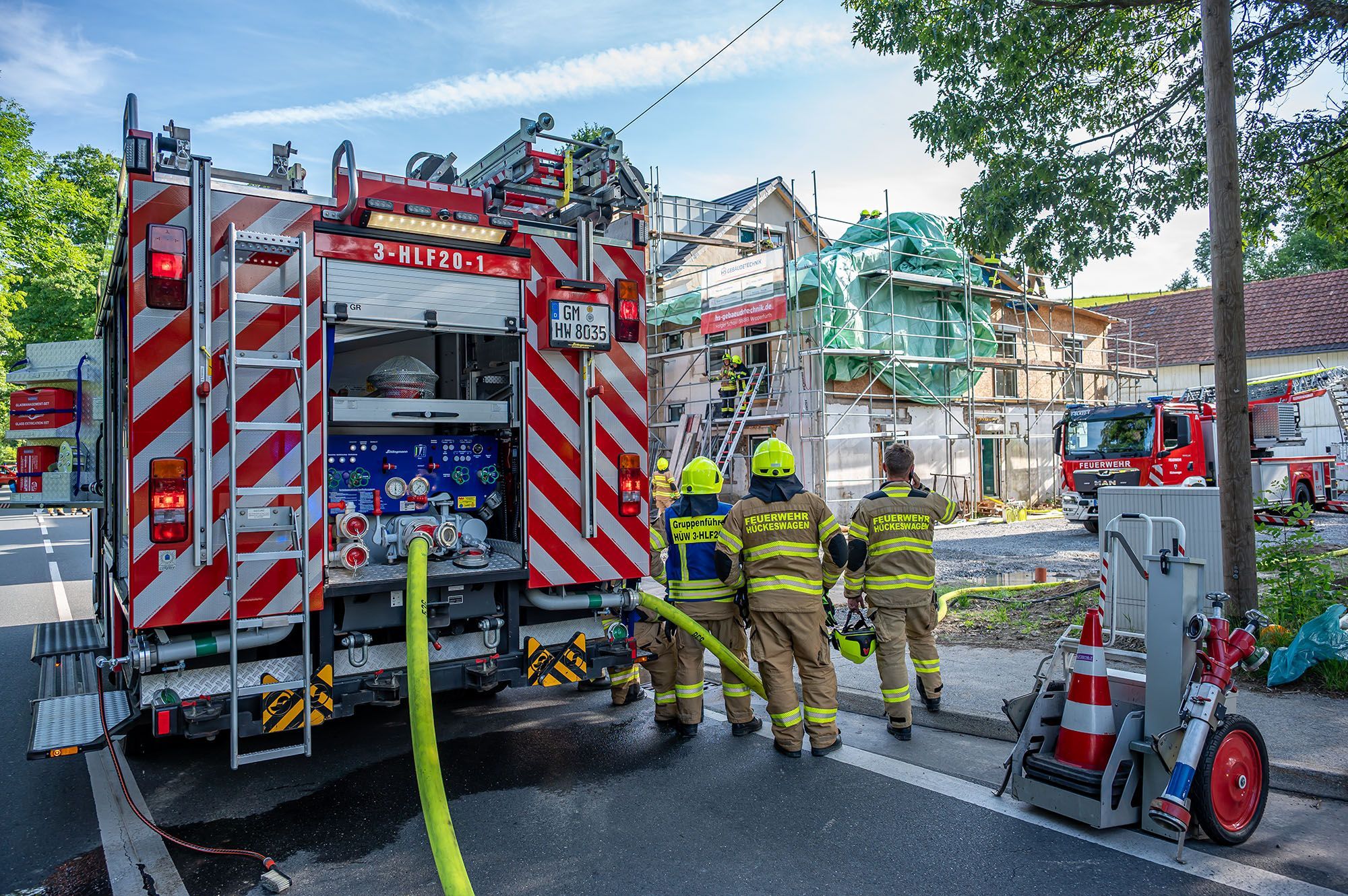 Die Feuerwehr steht vor dem Haus.