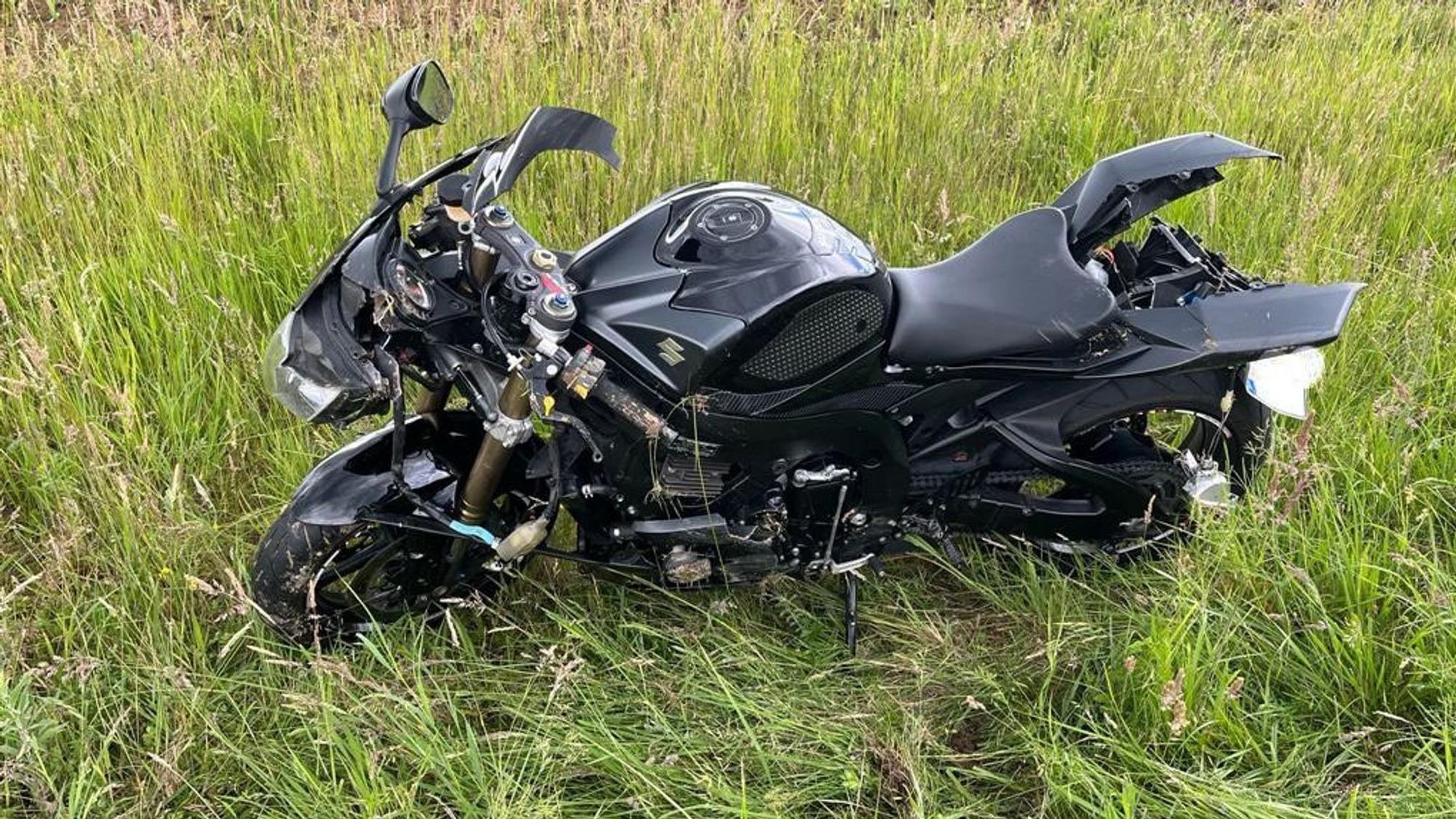Ein Motorradfahrer liegt nach einem Sturz neben seiner Maschine.