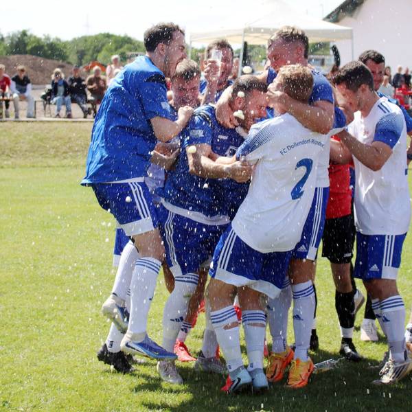 Fußballspieler jubeln, das Bier spritzt sie nass.