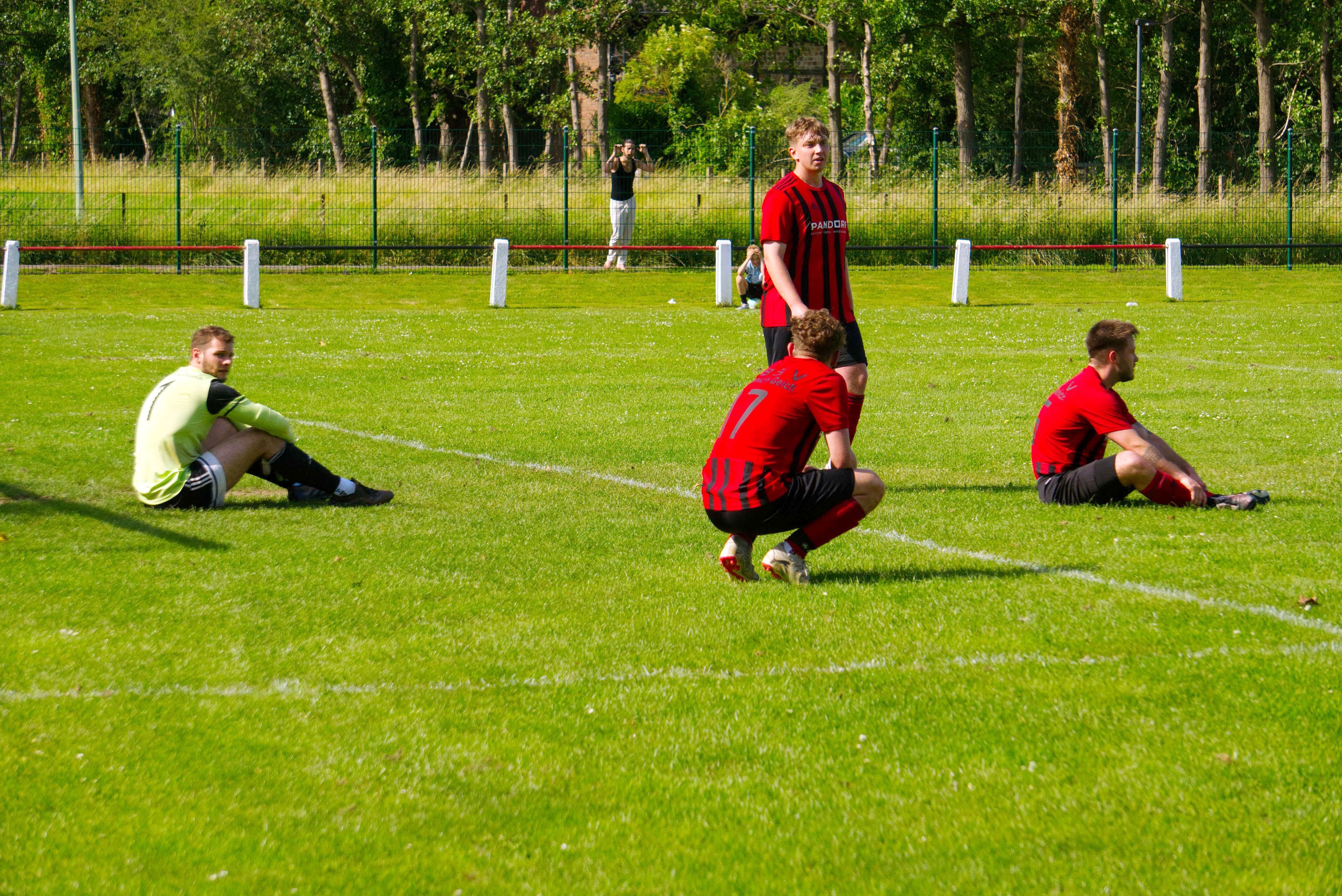 Spieler der TB-SV Füssenich-Geich sitzen traurig auf dem Spielfeld.