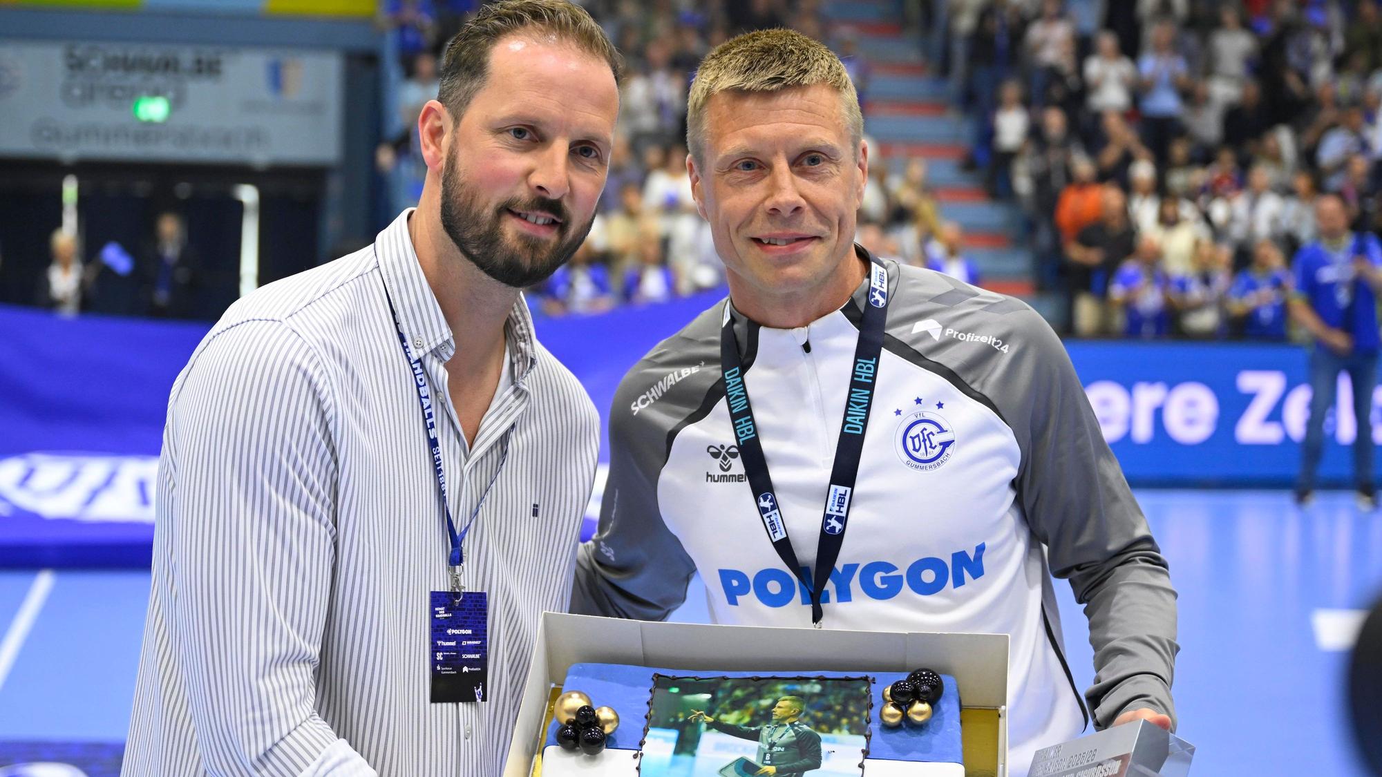 Schindler überreicht Sigurdsson einen Kuchen.