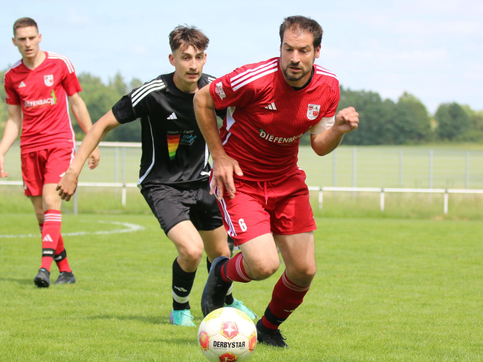 Dahlems Kapitän ist am Ball und wird von einem Gegenspieler verfolgt.